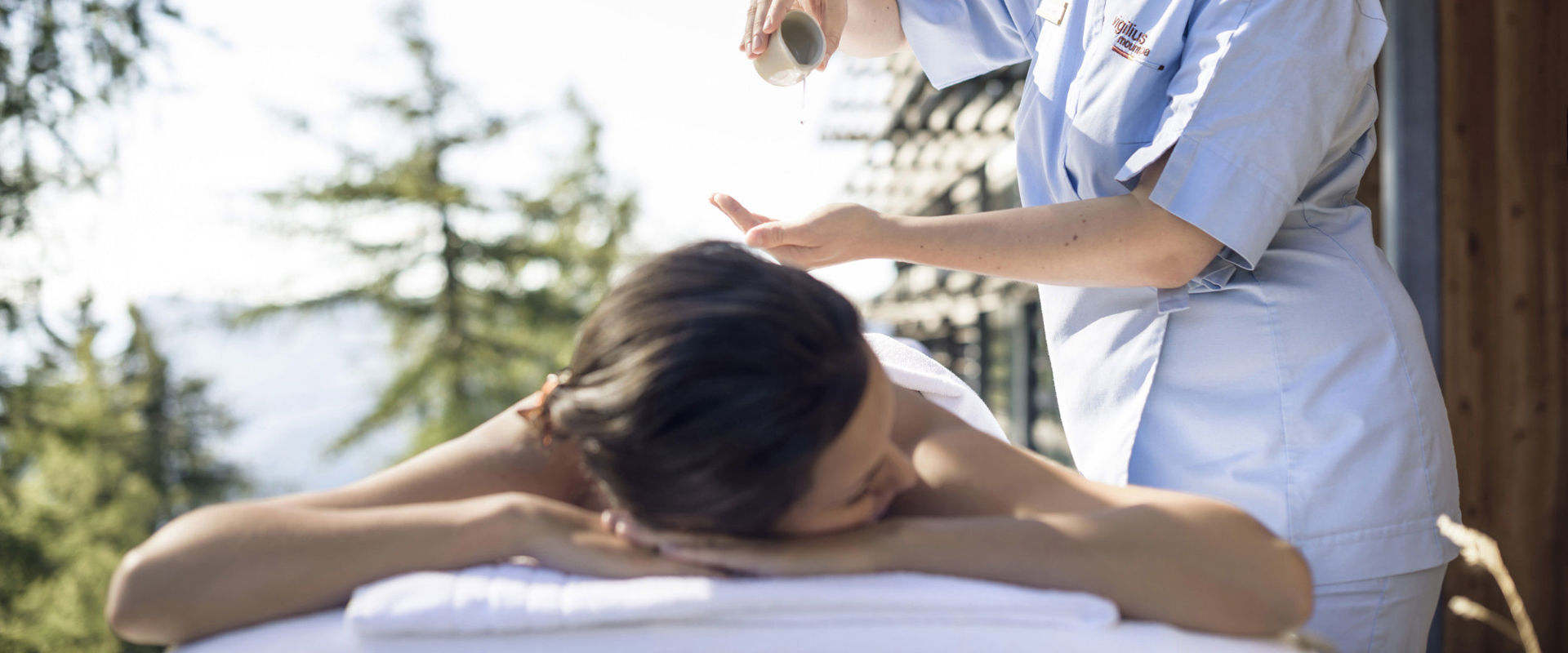 Wellnessbehandlung Frau auf einer Liege wird mit Öl massiert.