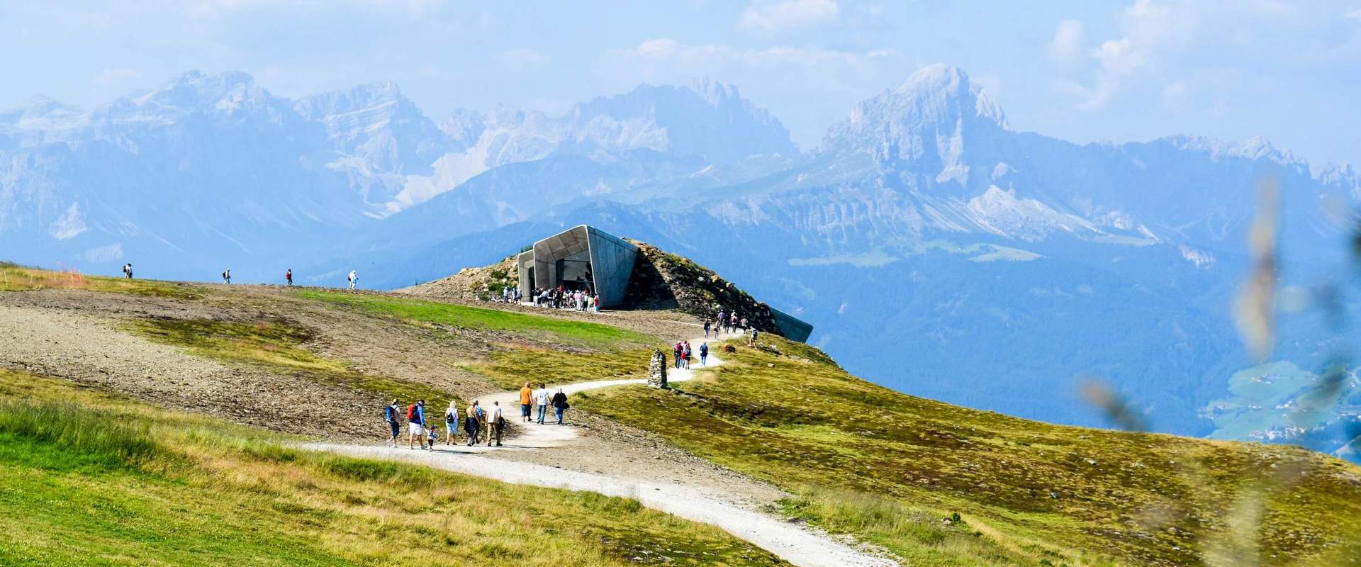 MMM Corones MMM Corones mit Besuchern am Kronplatz-Gipfel & grüne Wiesen