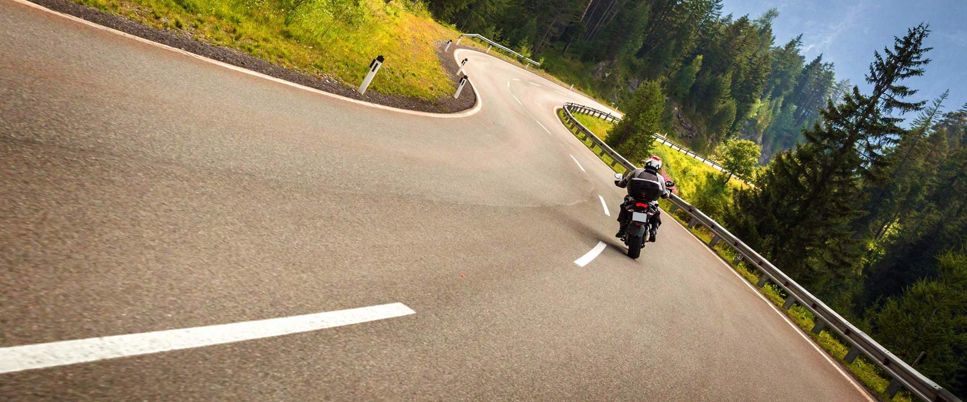 Motorradfahren in Südtirol Mit dem Motorrad durch Wälder und Berge kurven.