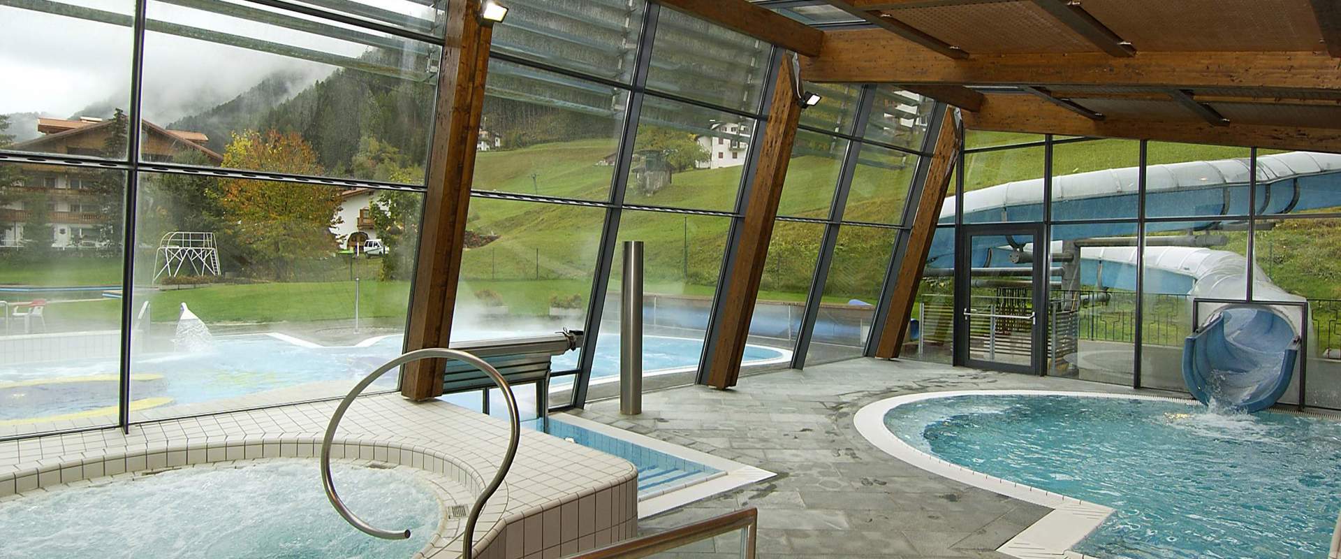 Innen- und Außenbereich Schwimmbad mit Rutsche.