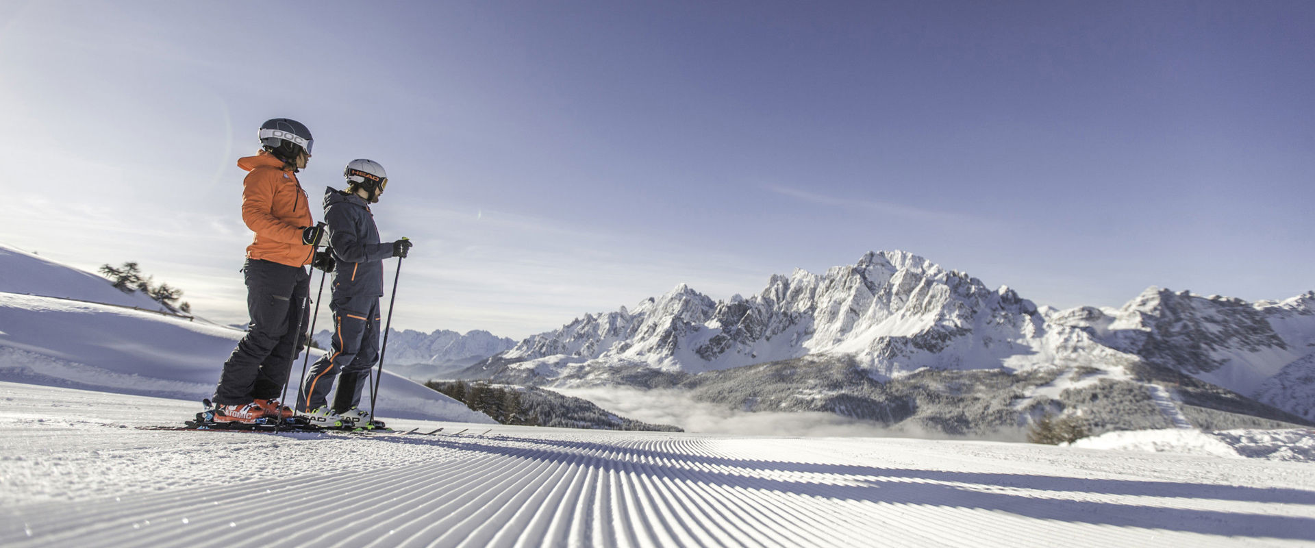 Skifahrer 2 Skifahrer stehen am Rande der frisch präparierten Skipiste.
