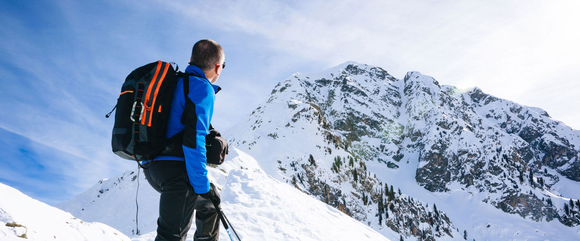 Bergsport im Winter Auf den Berggipfel angekommen bewundert ein Skifahrer das Naturschauspiel um ihn herum.