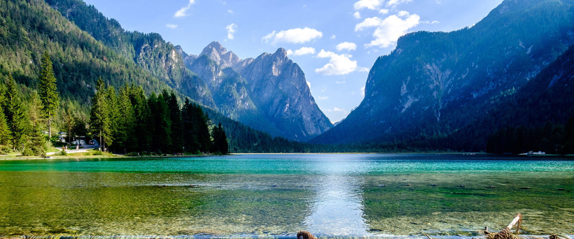 Toblacher See. Wasserstufe von türkisgrünem See umrahmt von Bergen.