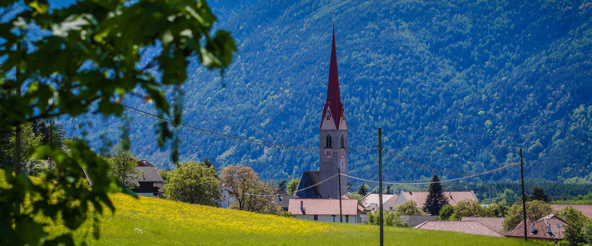 Schabs Pfarrkirche von Schabs im Sommer mit grünen Wiesen