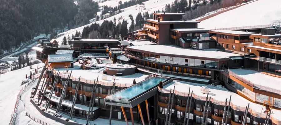 Blick auf die Hubertus Hotelterrasse mit Skypool und atemberaubender Aussicht auf die Berge im Winter
