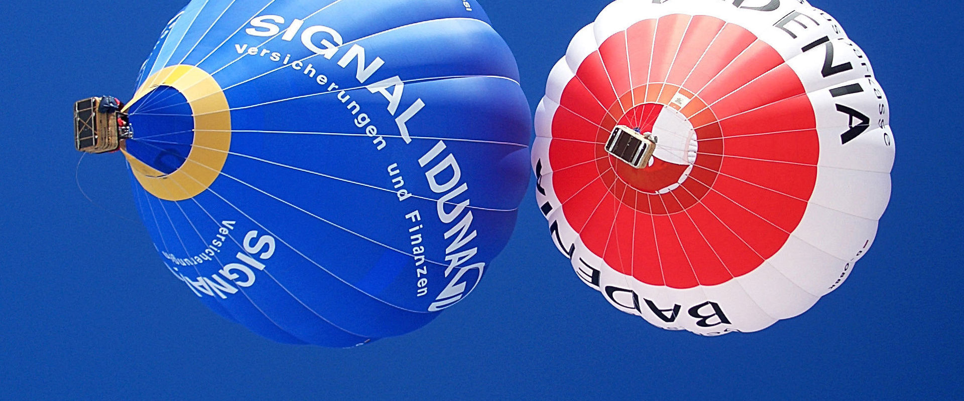 Heißluftballonfahrten in Südtirol. Zwei Heißluftballons färben den blauen Himmel über Südtirol.