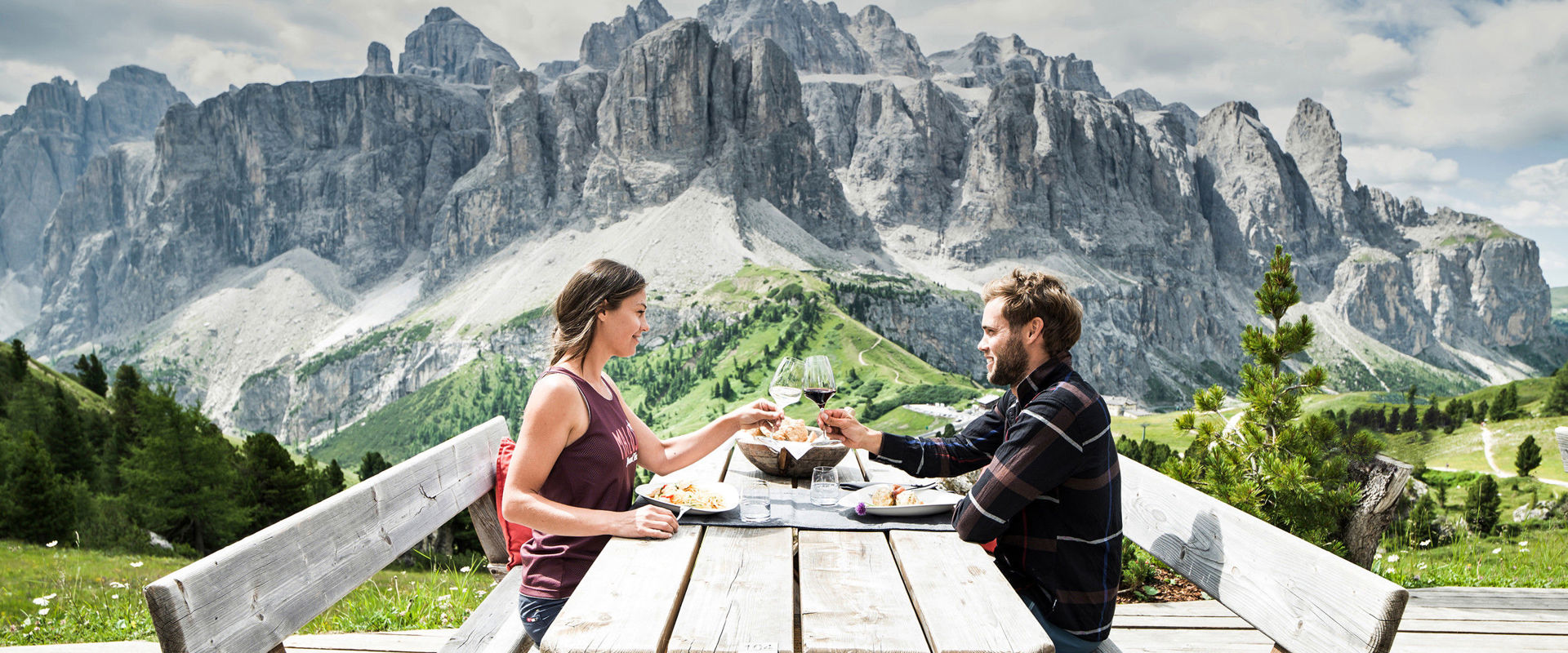 Paar beim Weintrinken & Essen auf einer Terrasse in den Dolomiten