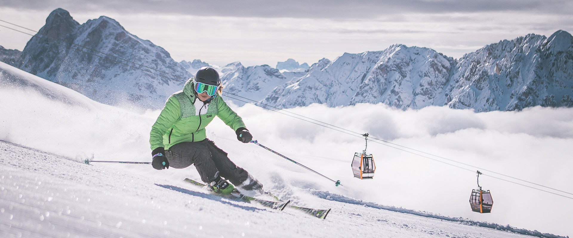 Plose Skifahren Skifahrerin auf den Pisten der Plose mit Kabinenbahn und Dolomiten