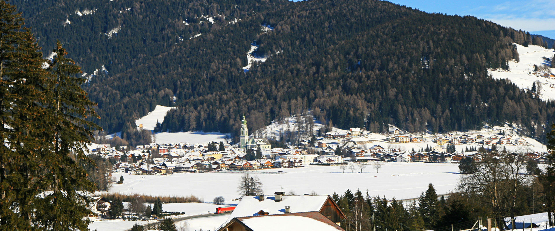 Blick auf Toblach mit Pfarrkirche im Winter