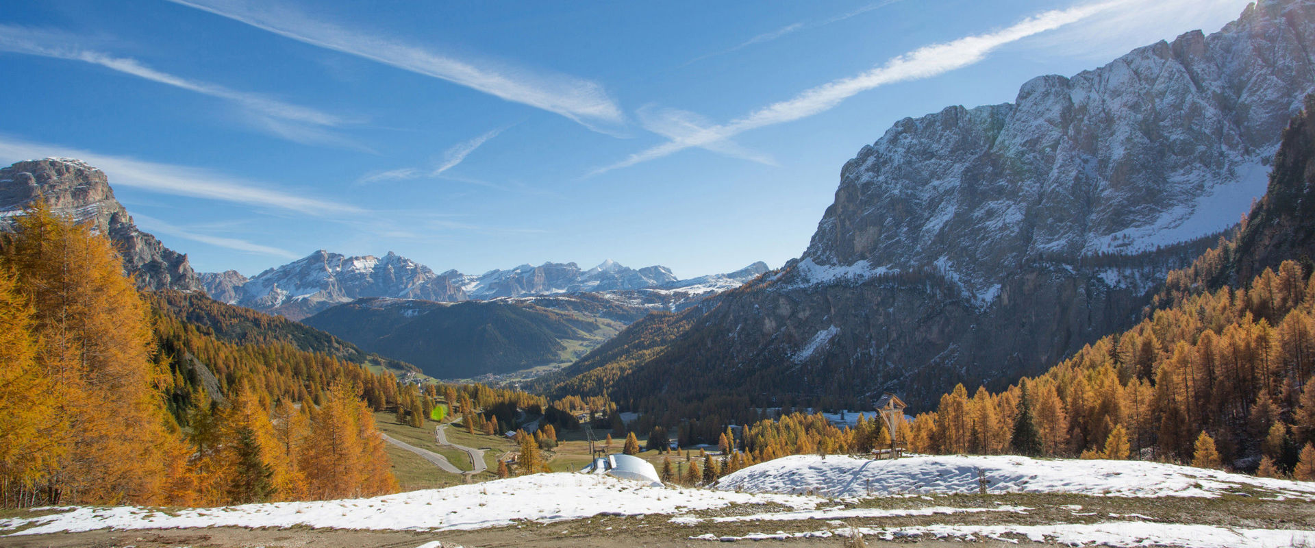 Schneelandschaft mit goldgelben Lärchen und Dolomiten bei Kolfuschg