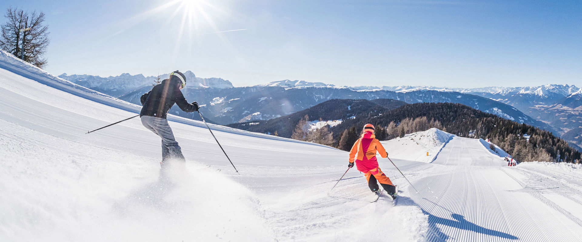 Dolomiti Superski 2 Skifahrer fahren die frisch präparierte Piste hinunter.