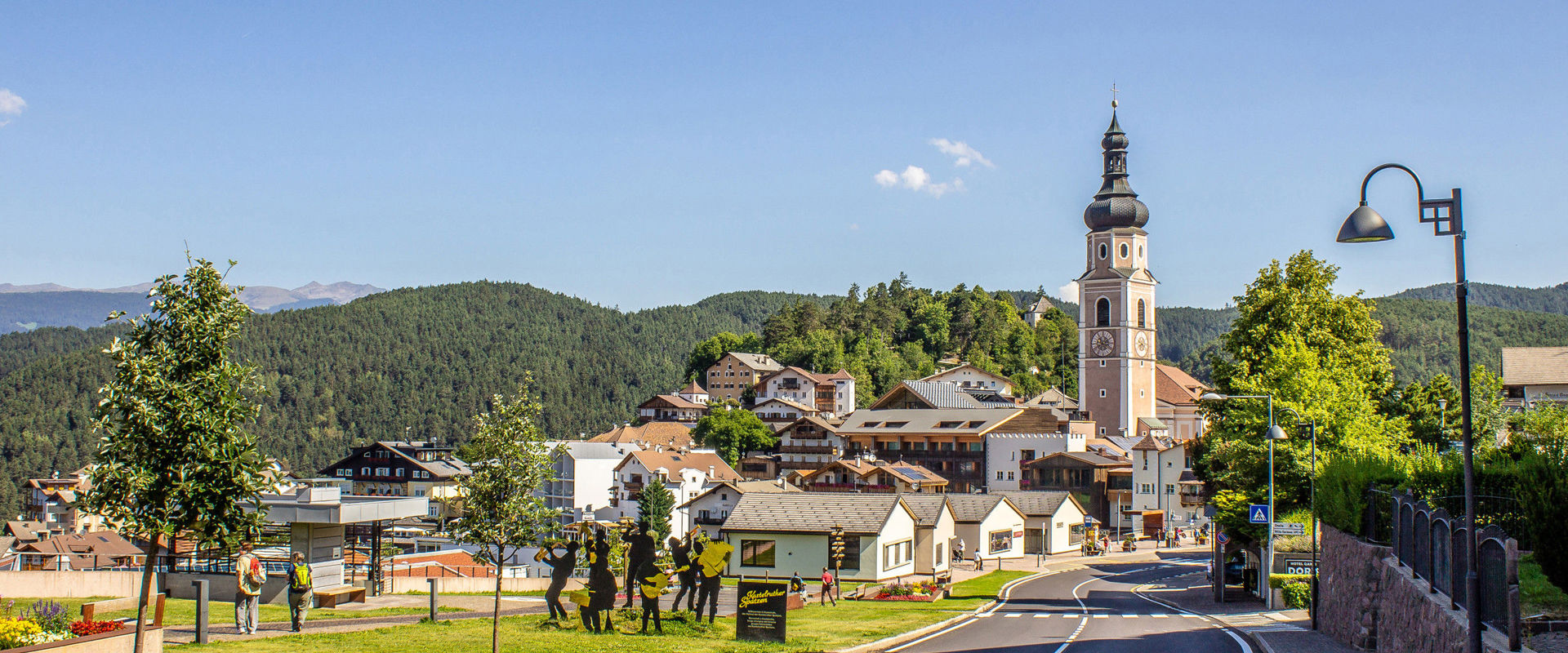 Kastelruth mit Kirchturm und Häusern.
