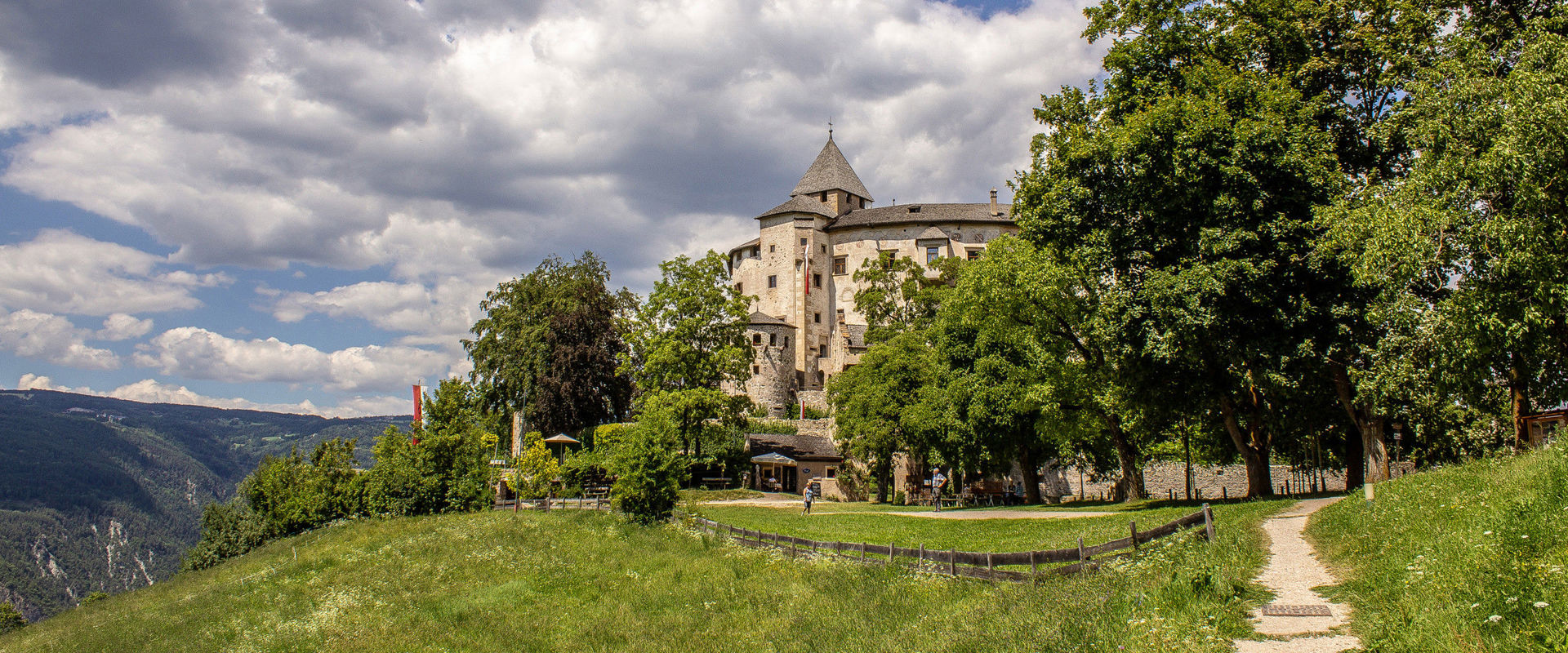 Schloss Prösels Auf einer Anhöhe mitten auf einer Wiese und versteckt zwischen hohen Bäumen führt ein kleiner Pfad zum wunderschönen Schloss Prösels.