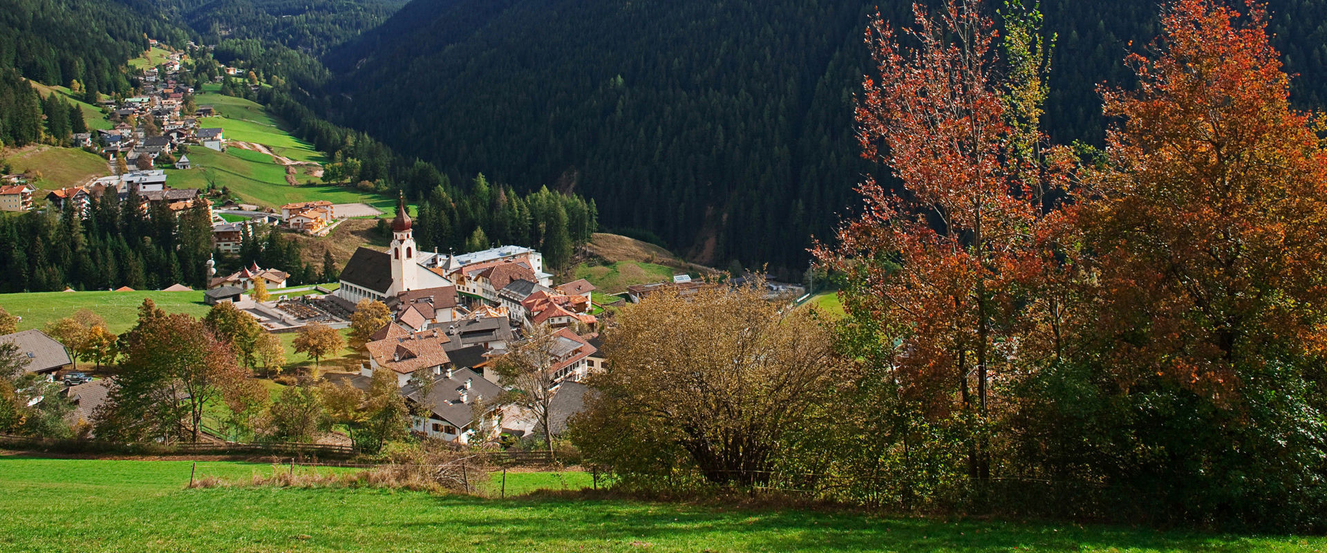 Welschnofen Häuser und Pfarrkirche Welschnofen mit herbstlichem Wald und Latemar
