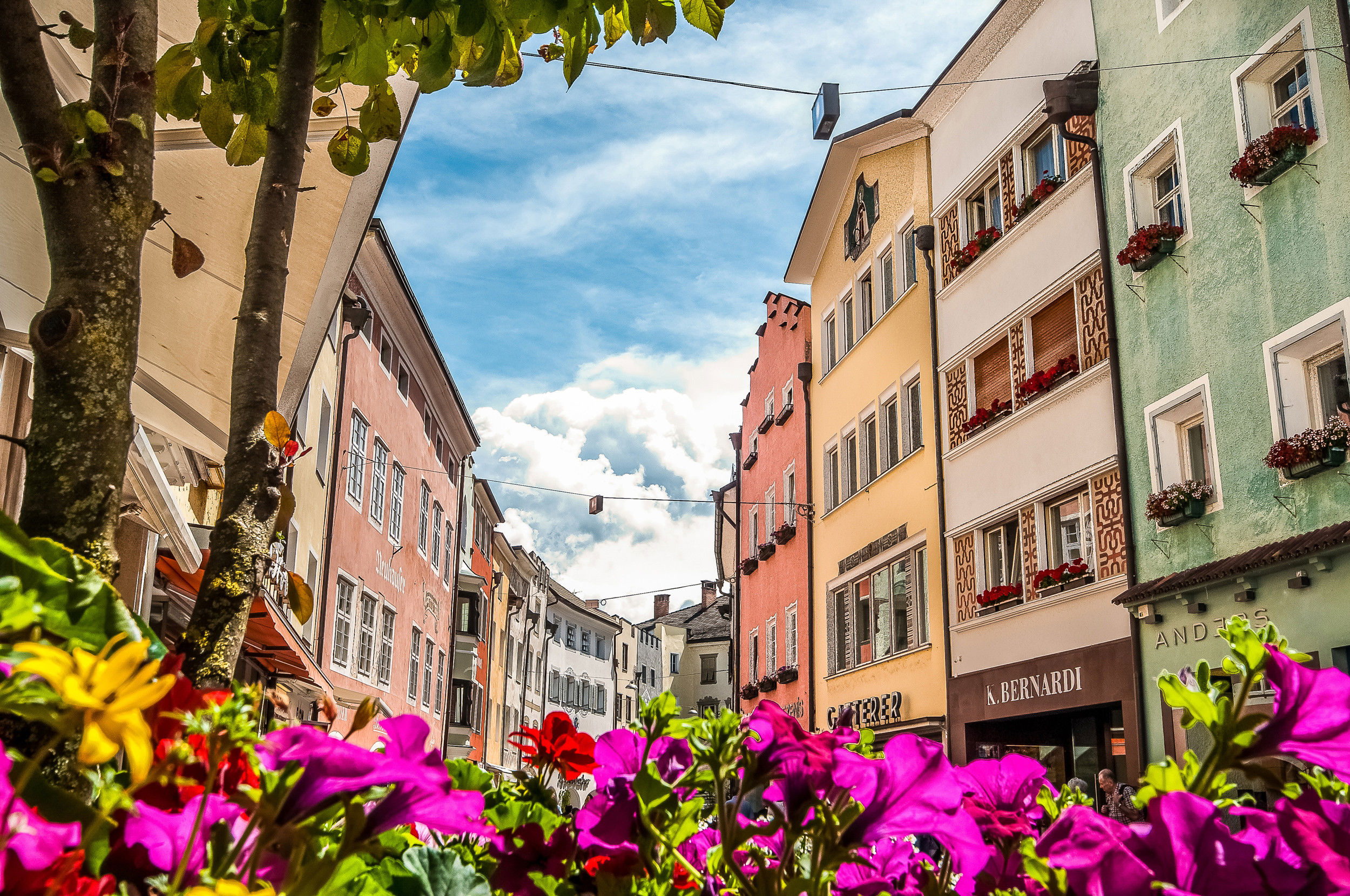 Die Brunecker Altstadt im Sommer mit blühenden Blumen.