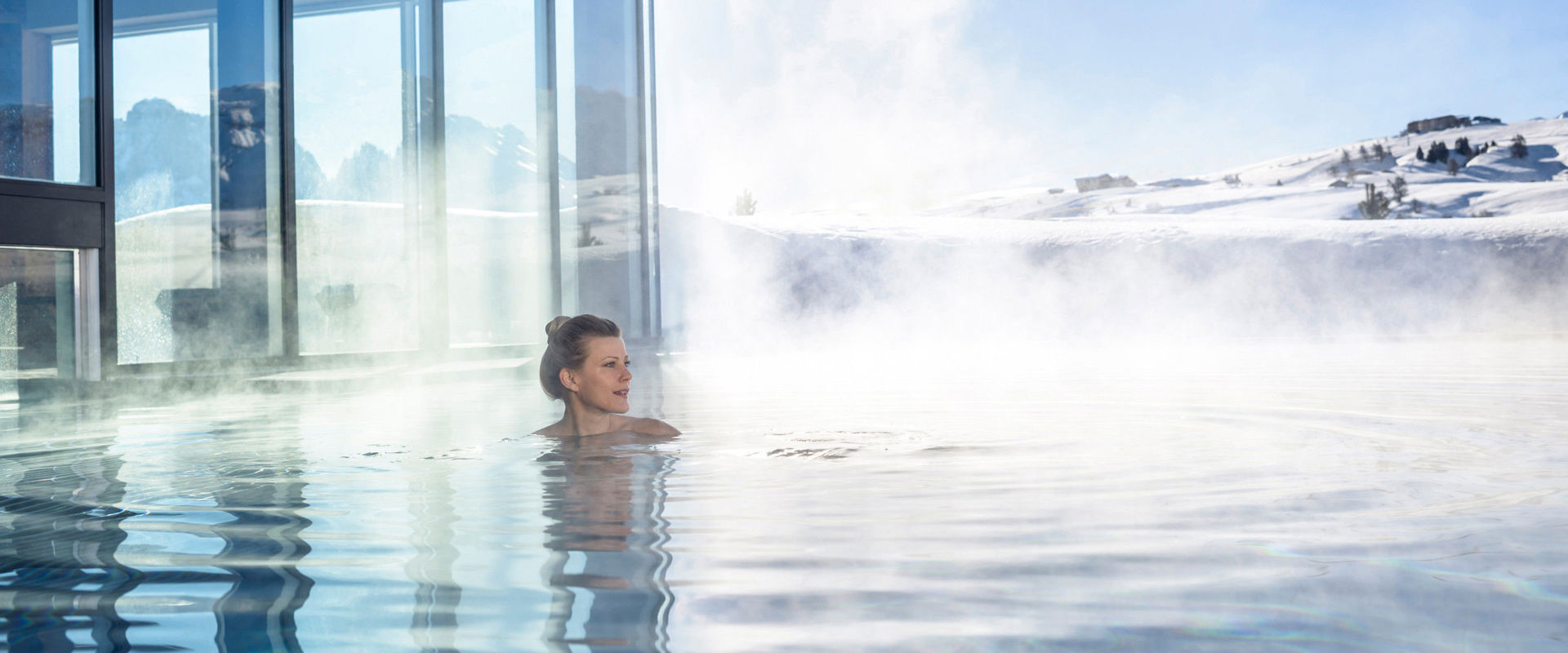Außenpool Eine Frau schwimmt im warmen, dampfenden Außenpool.