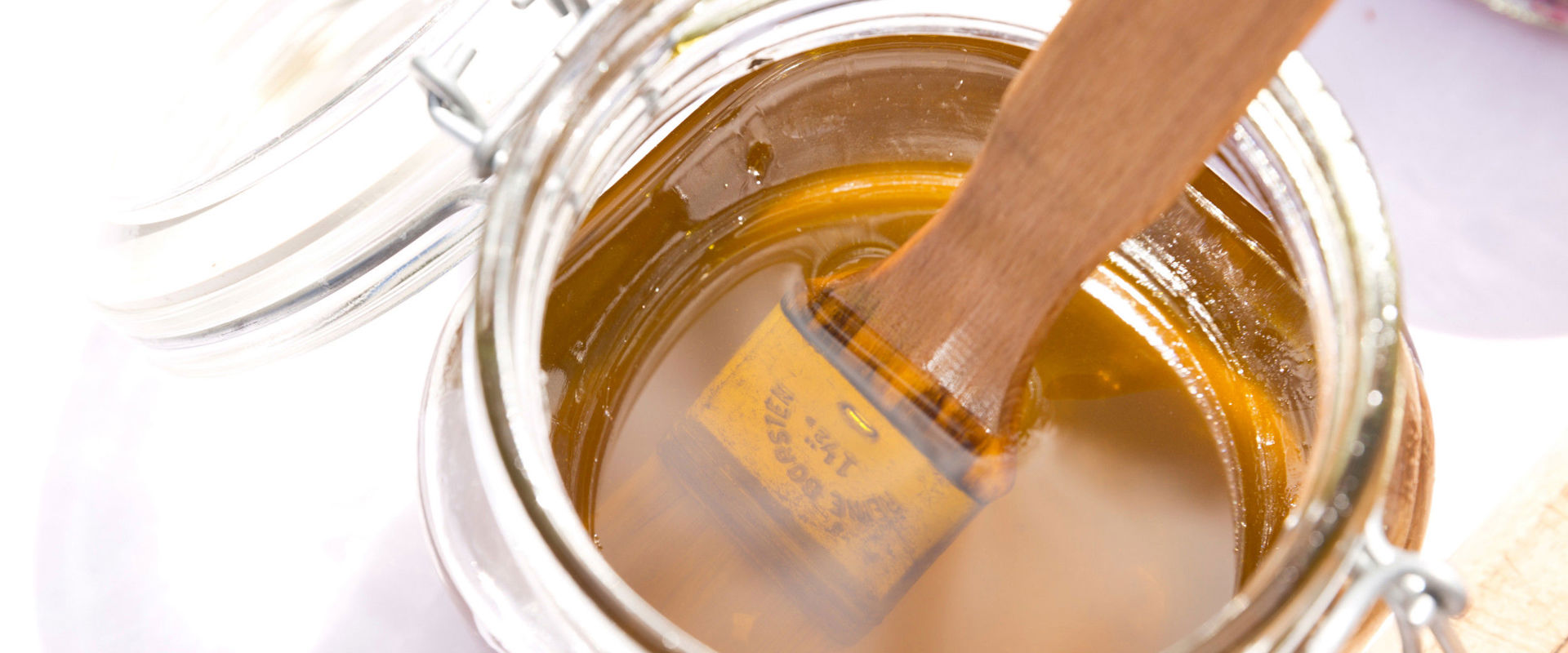 Glas mit Bienenhonig und Pinsel.