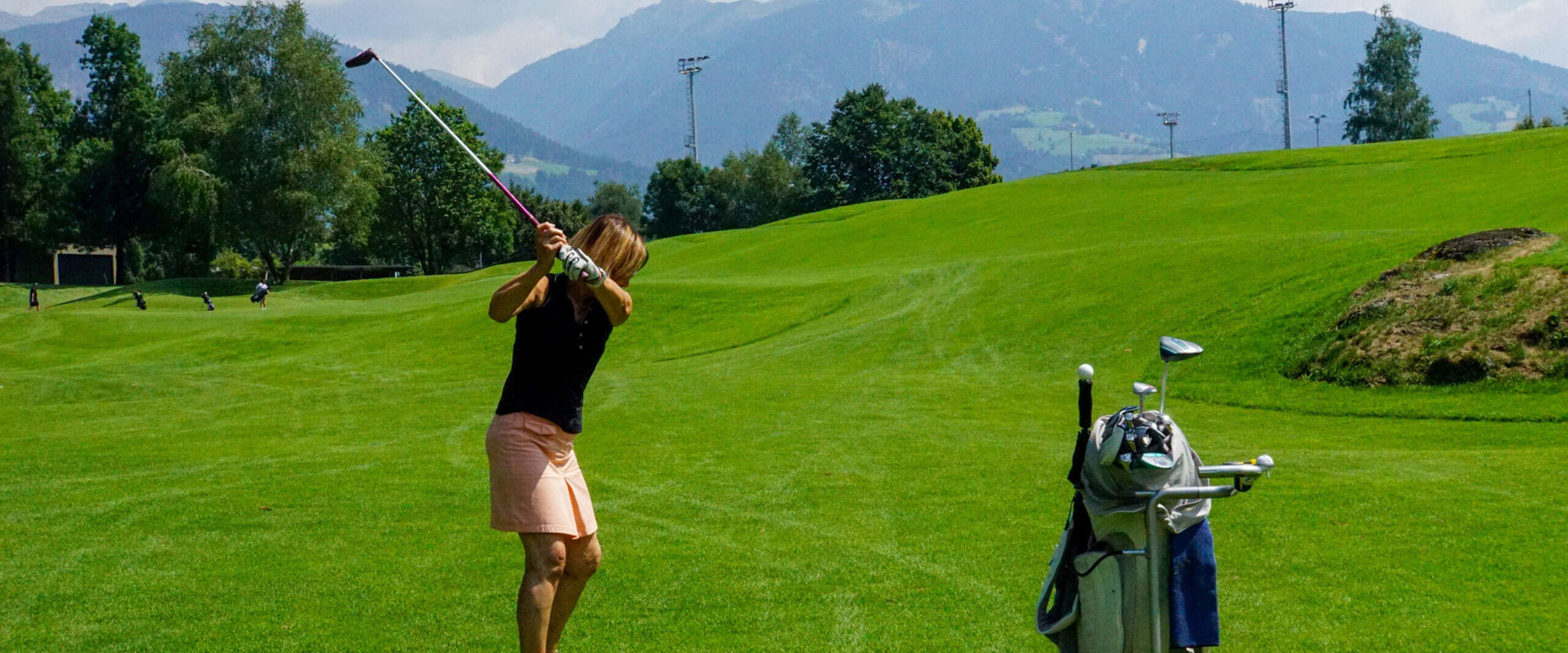 Frau am Golfplatz Frau steht auf dem Golfplatz und ist zum Abschuss bereit.