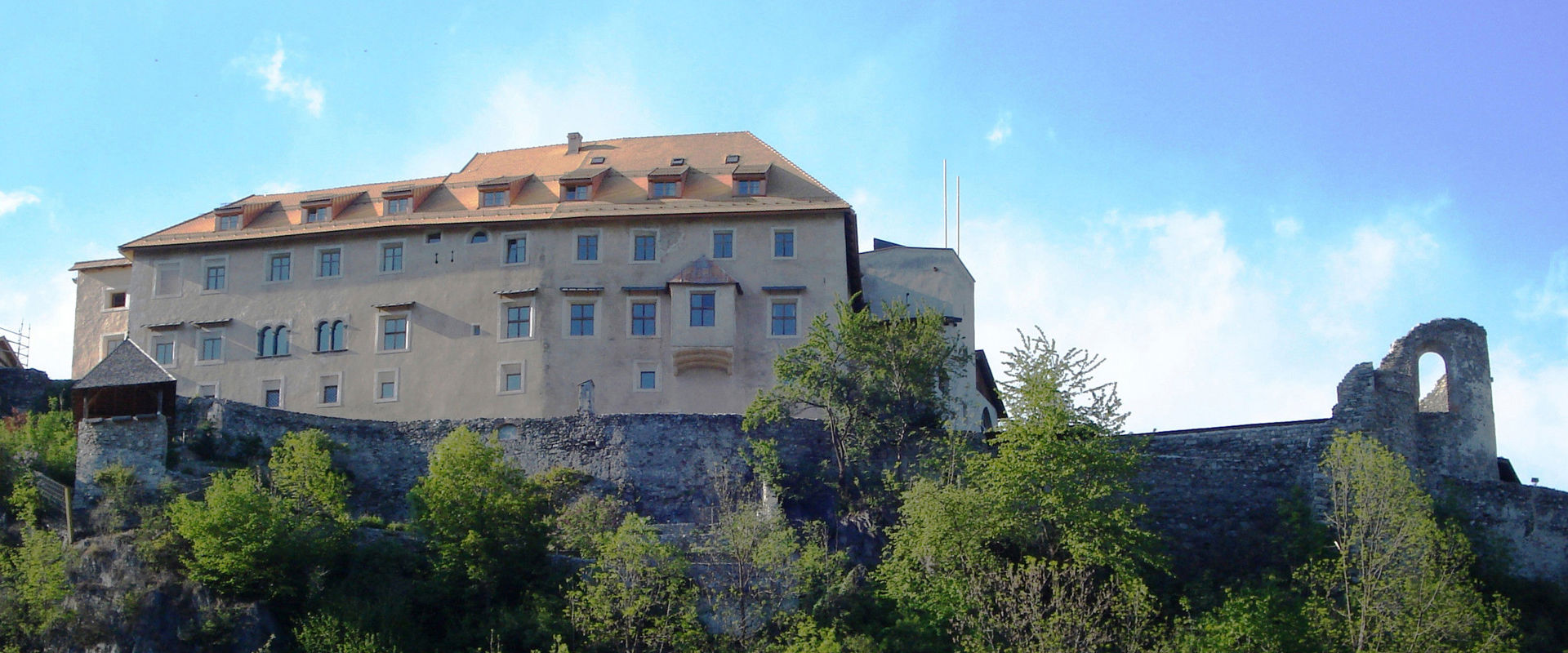 Schloss Sonnenburg mit den steilen Burgmauern mitten im Grünen.