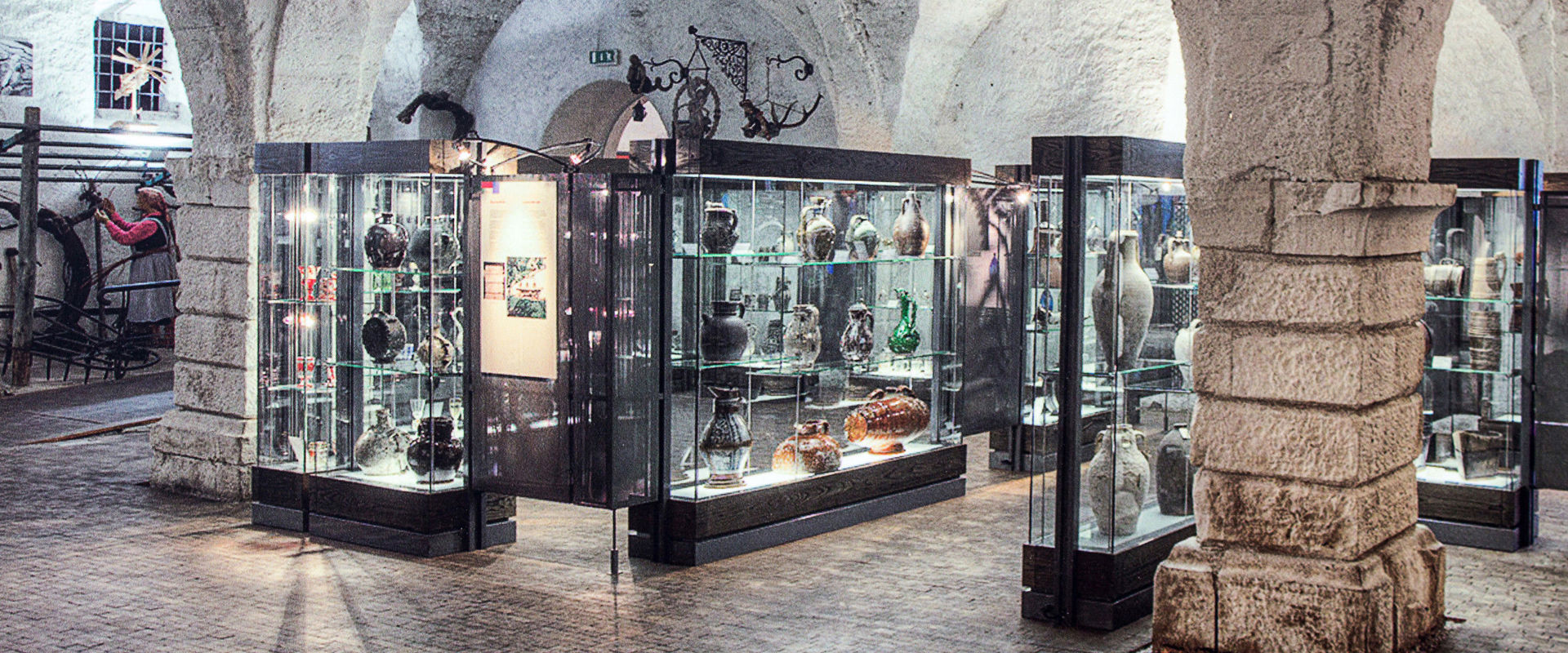 Weinmuseum in Kaltern Vitrinen mit verschiedenen Weingefäßen.