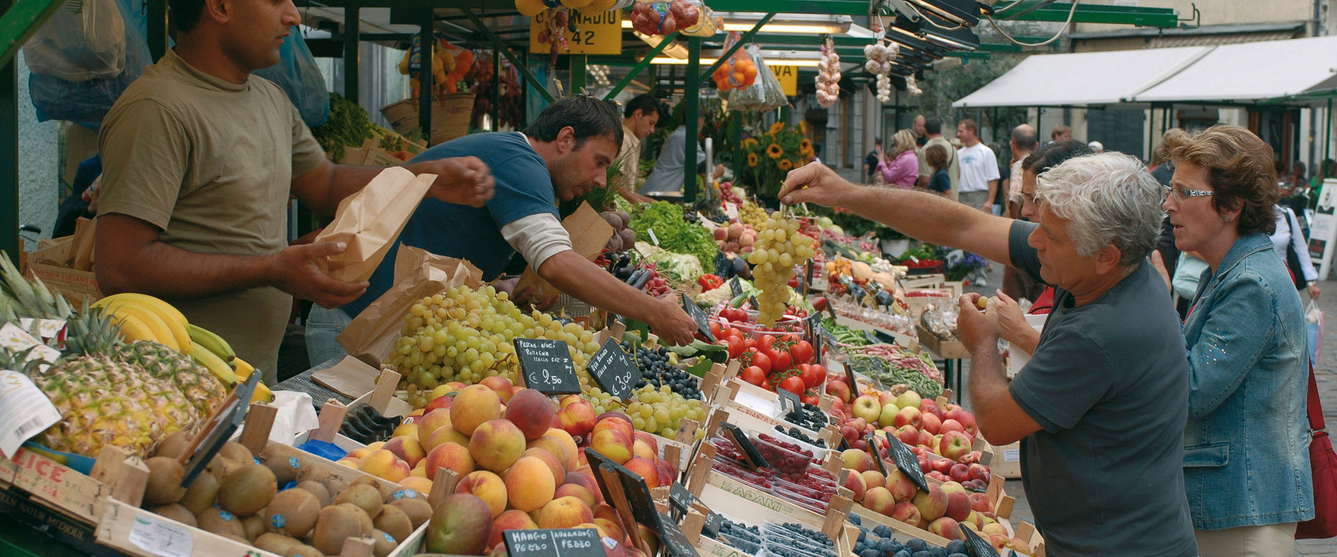 Einige Leute kaufen frisches Obst am Bozner Obstmarkt in der Altstadt.