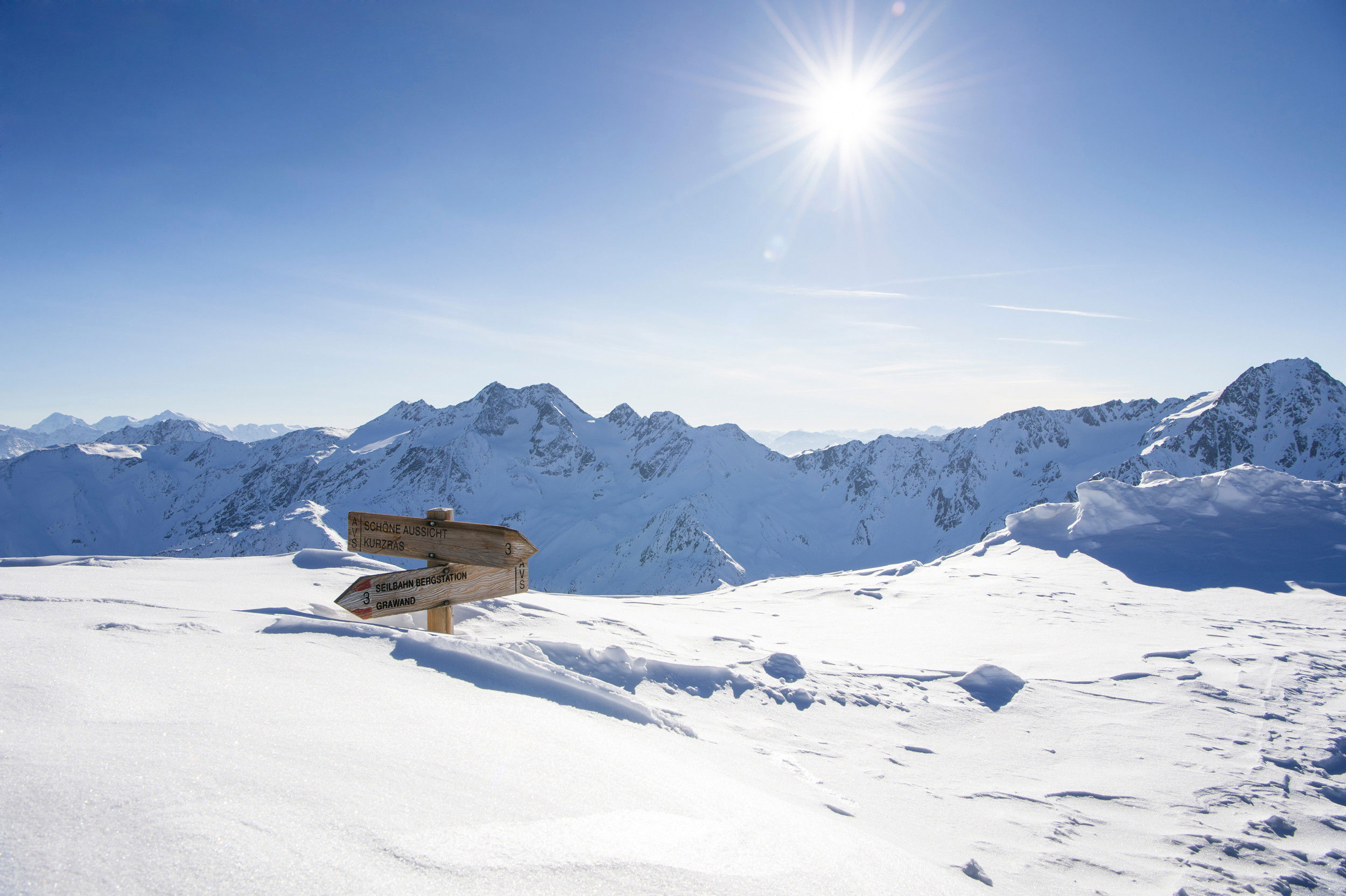 2 Wegweiser sind fast zur Gänze mit Schnee bedeckt.