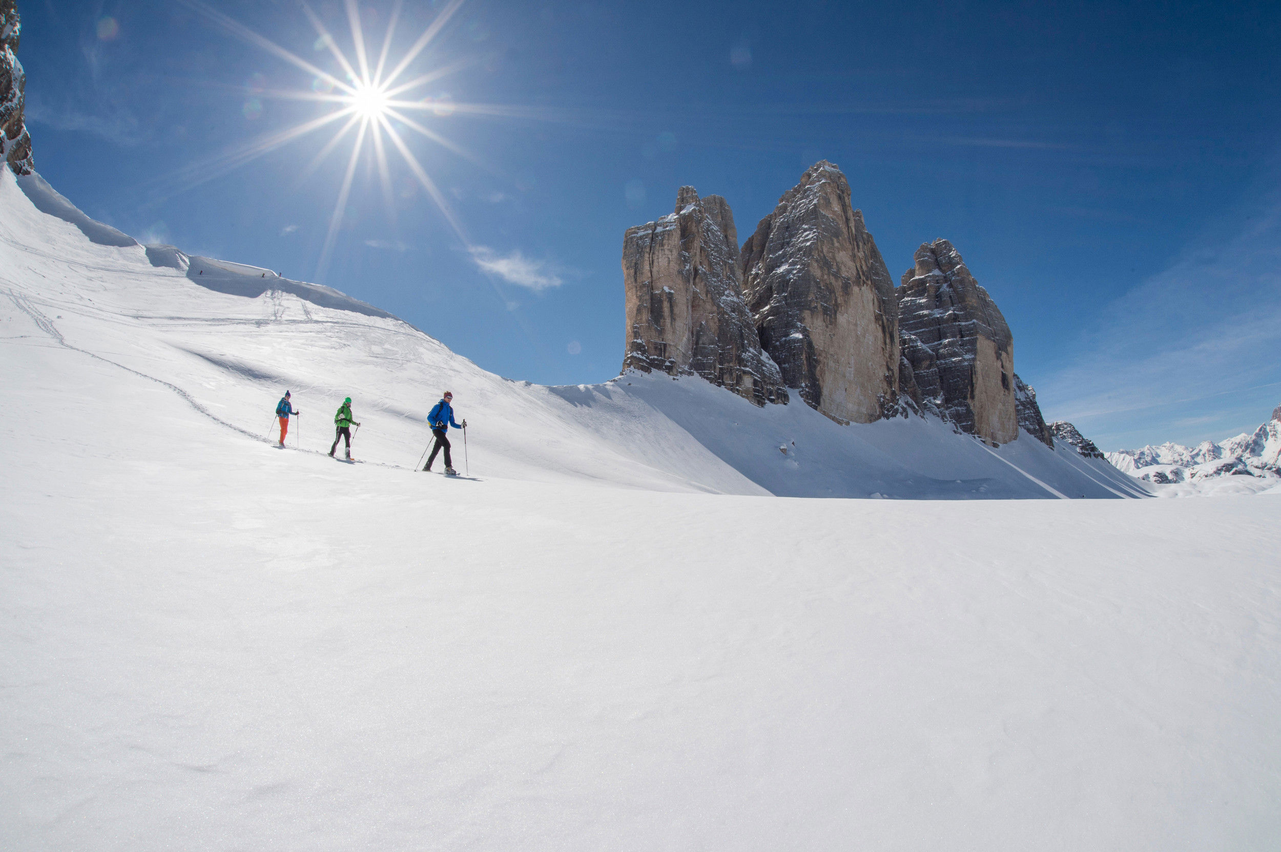 Schneebedeckte Winterlandschaft rund um den drei Zinnen mit 3 Tourengeher.