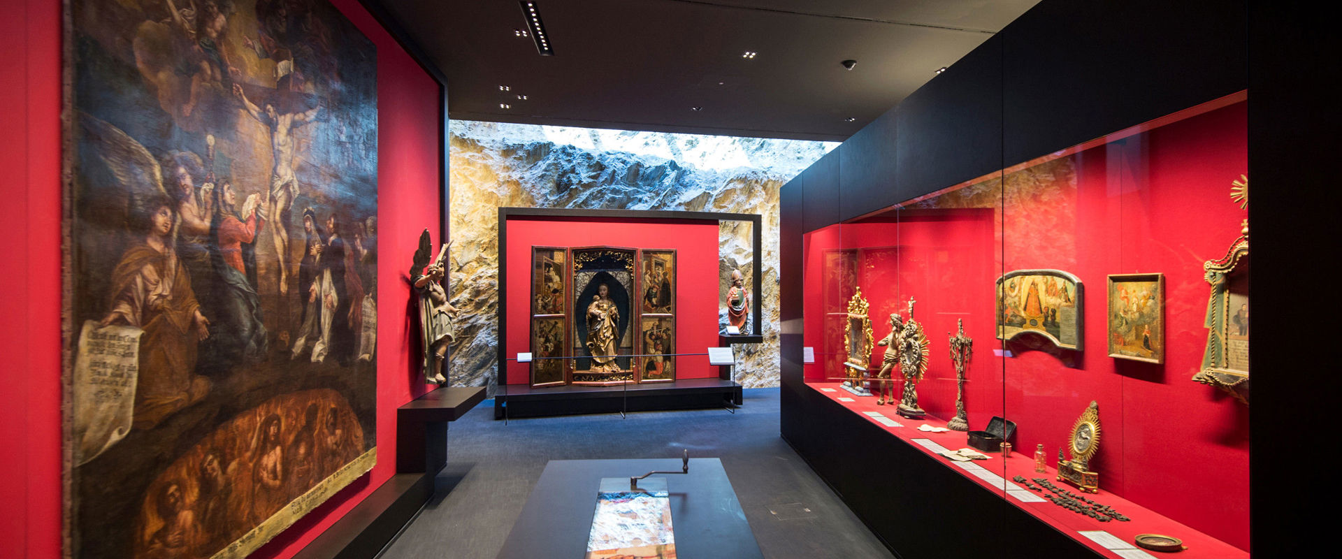 Palais Mamming Museum Innenraum des Museums mit roten Vitrinen.