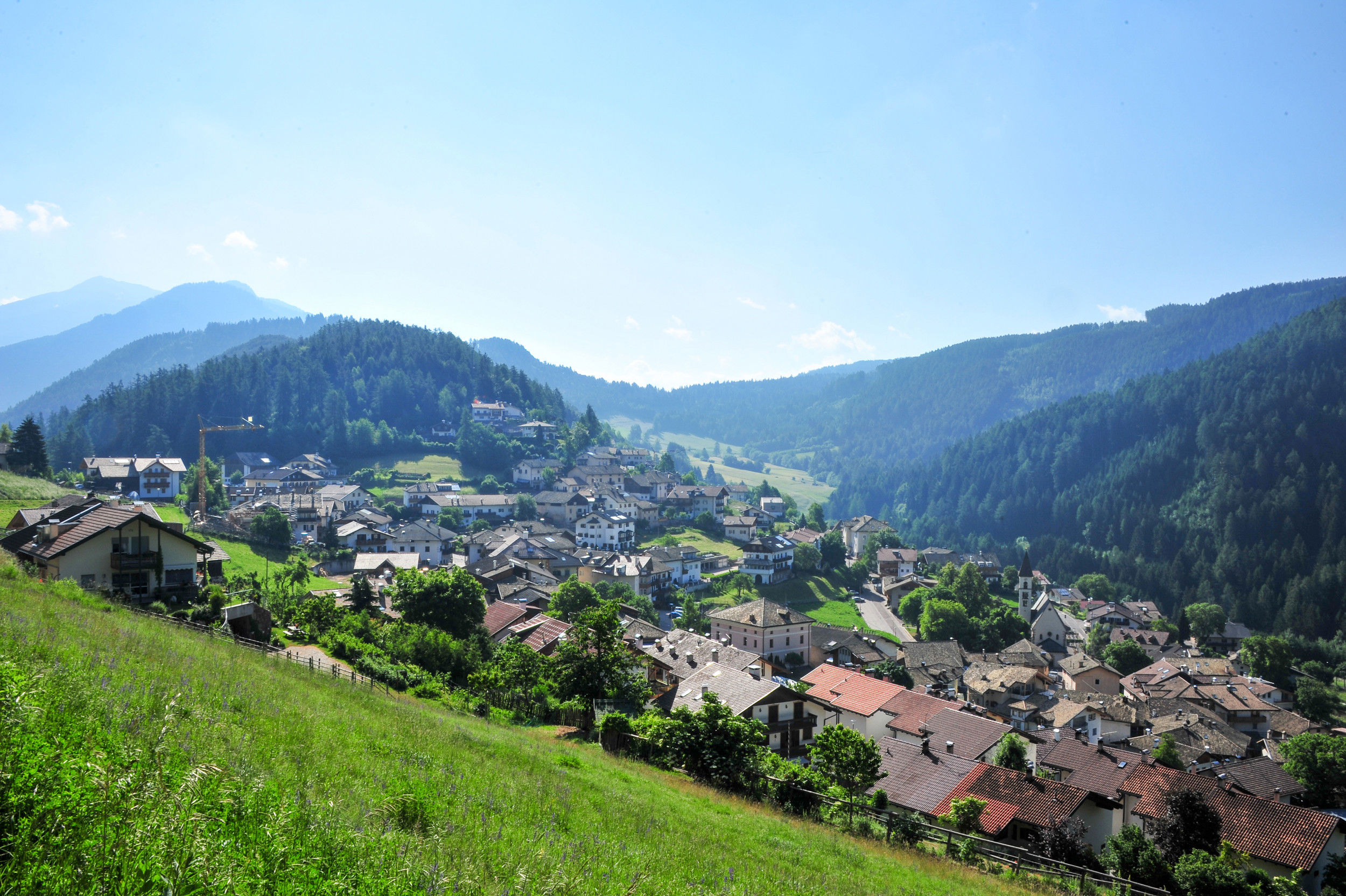 Blick auf Trunden eingebettet in einer sanften Hügellandschaft und umgeben von dichten Wäldern.