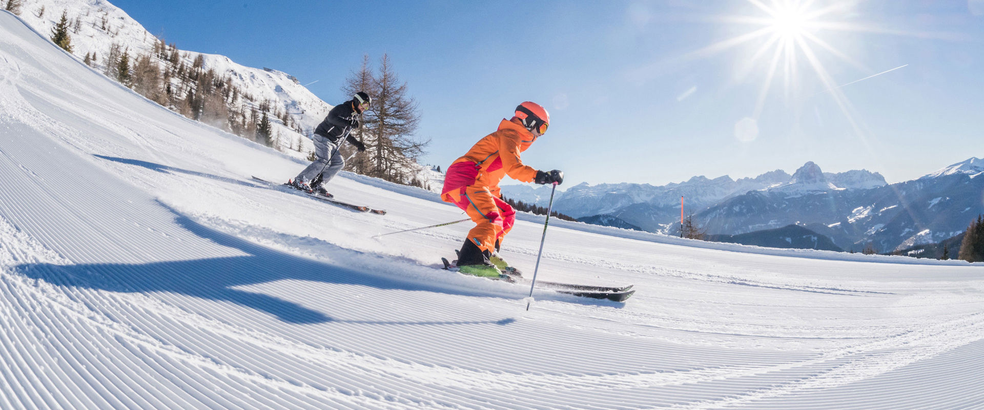 Frisch präparierte Skipiste 2 Skifahrer fahren die frisch präparierte Piste hinunter.