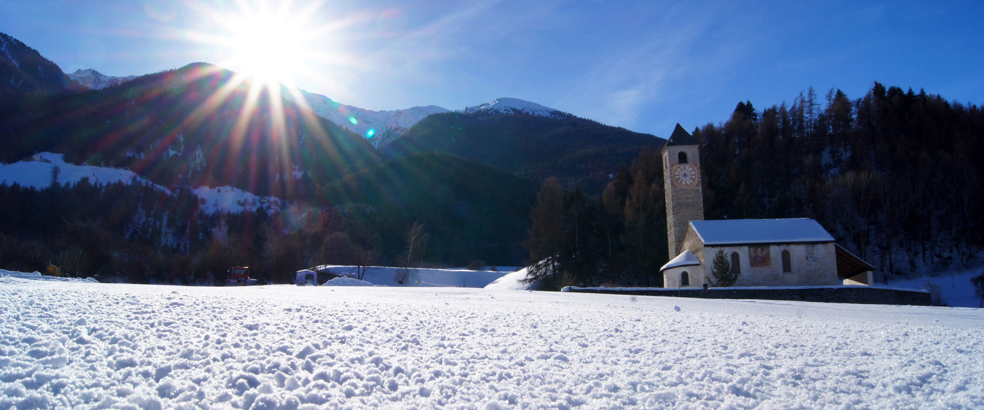 Lichtenberg in Prad am Stifserjoch. Schneelandschaft mit Kirche.