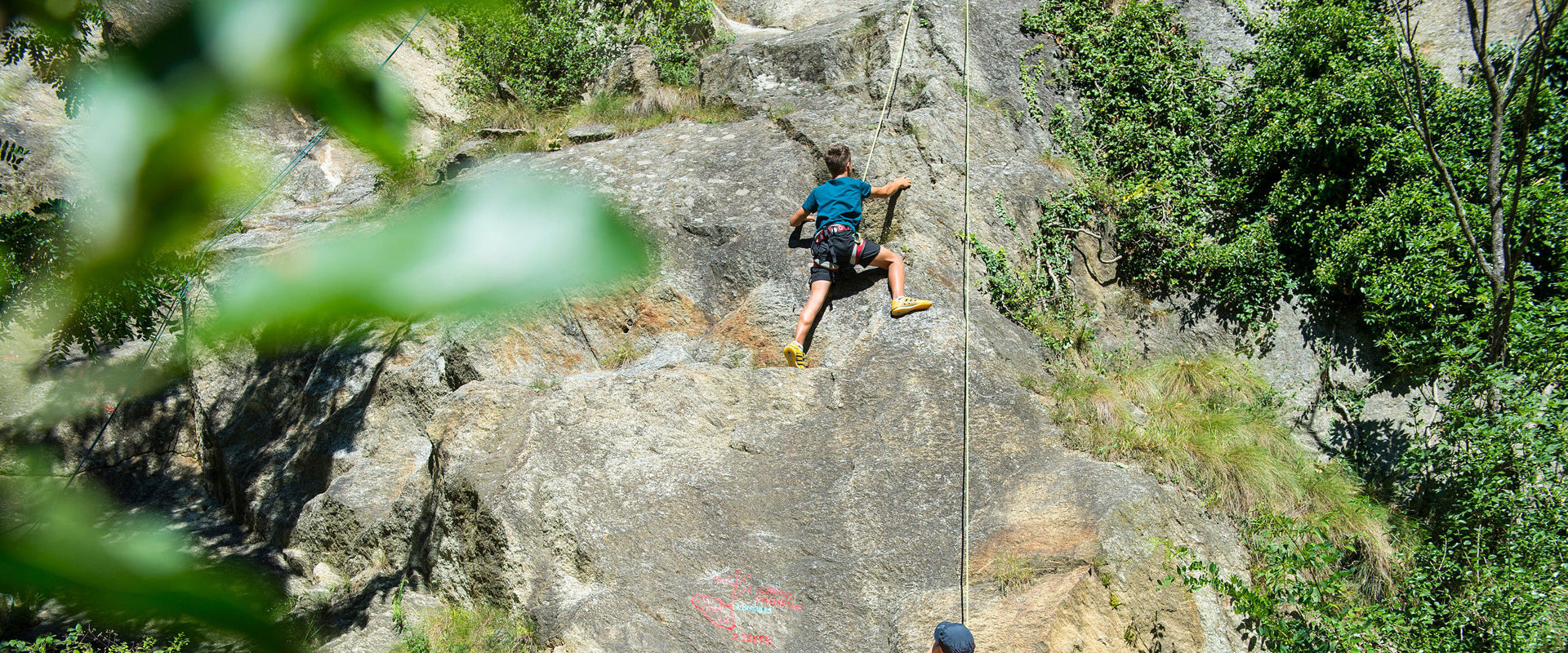 Klettergärten in Südtirol - Klettern im Freien Vater und Kinder klettern zusammen im Klettergebiet Juval bei Naturns.
