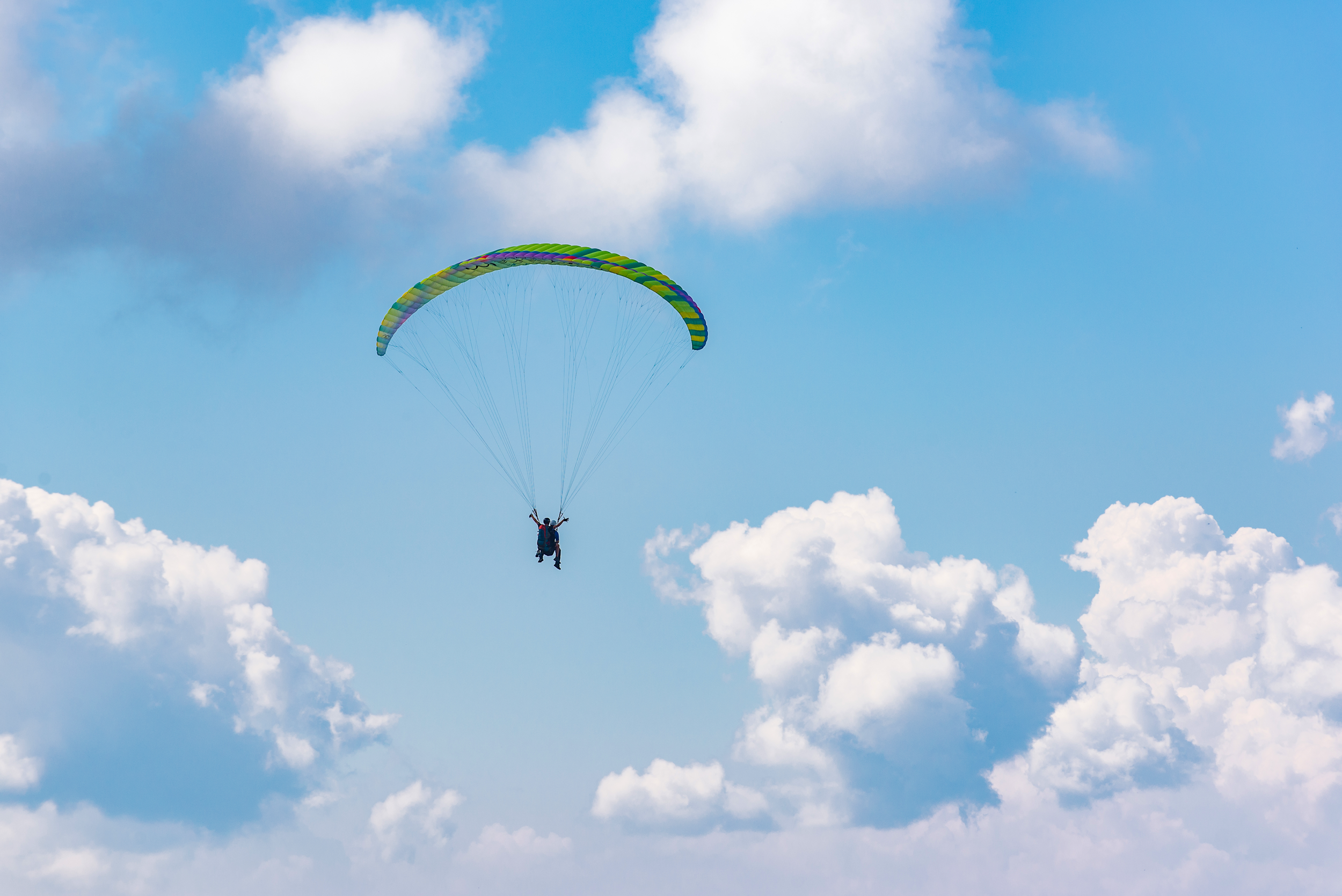 Gleitschirmfliegen in der Morgendämmerung über den Wolken.