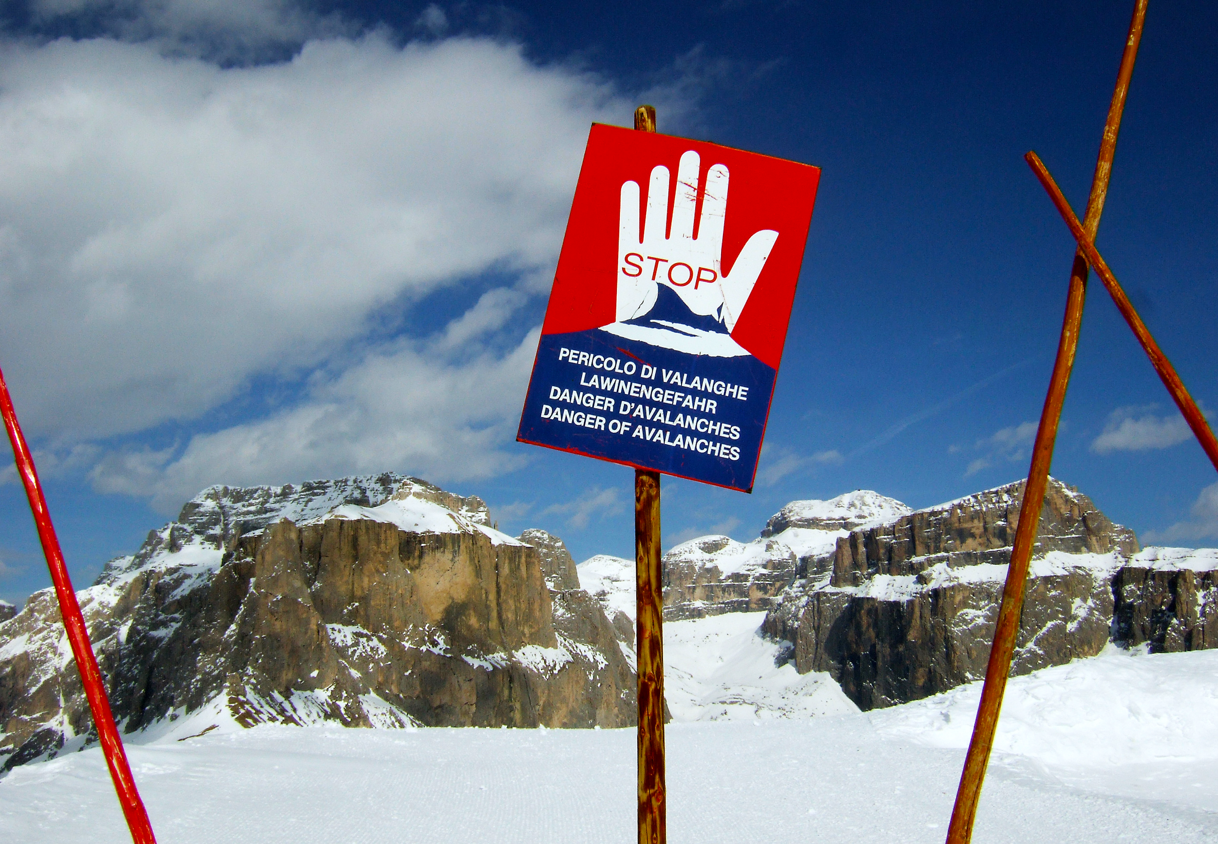 STOP-Schild Lawinengefahr in schneebedeckter Landschaft.