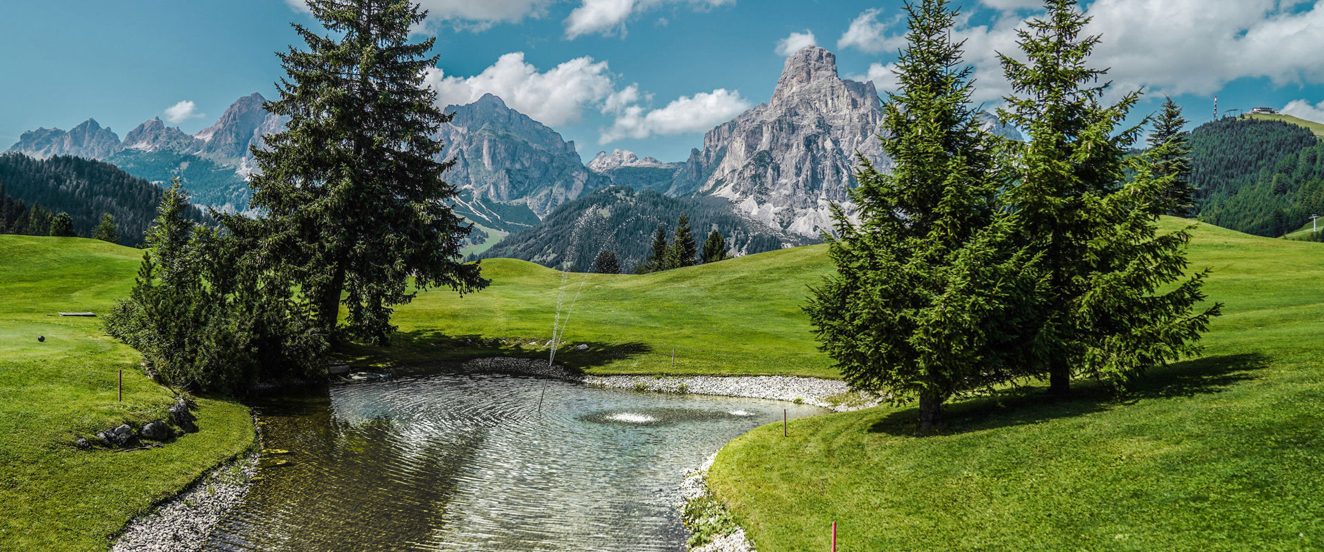Blick von einem Wasserreservoire am Golfplatz auf die atemberaubenden Gipfel der Dolomiten.