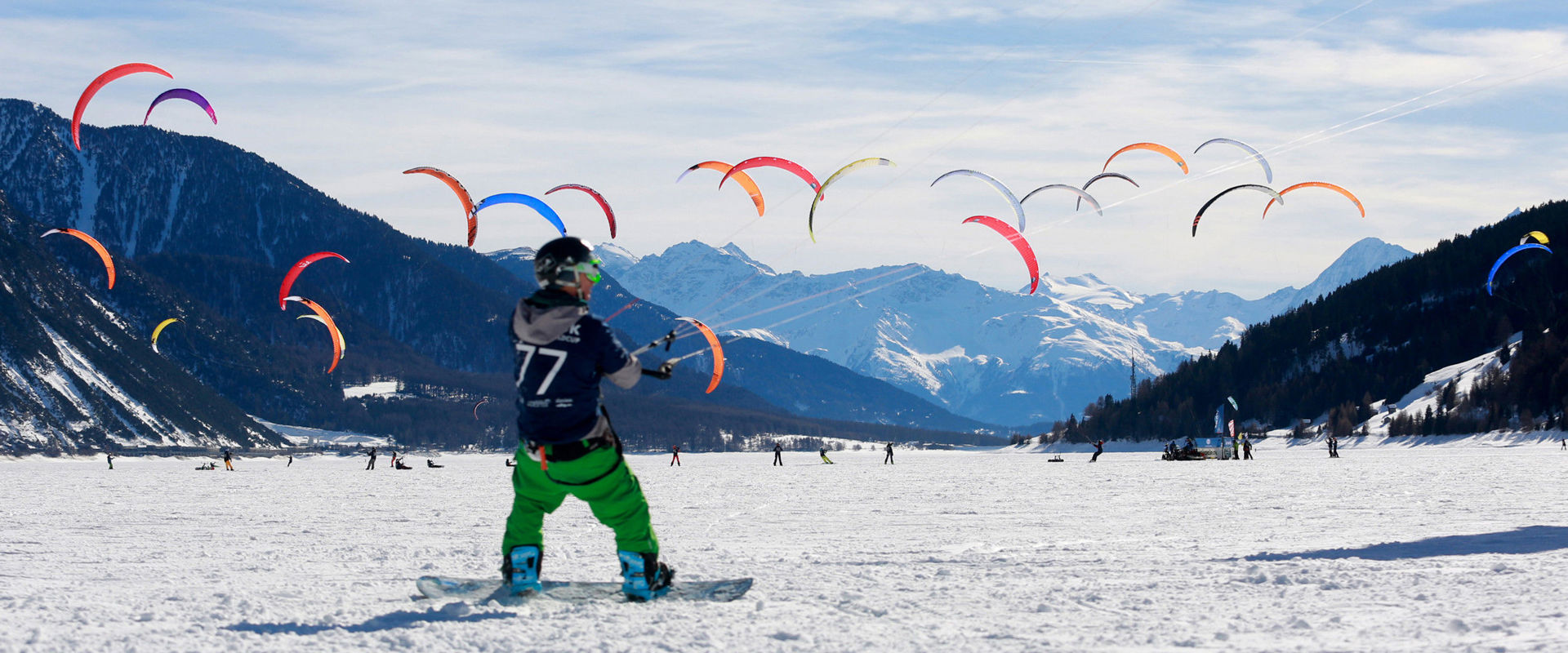 Snowkiting Snowkiters auf dem schneebedeckten Reschensee.