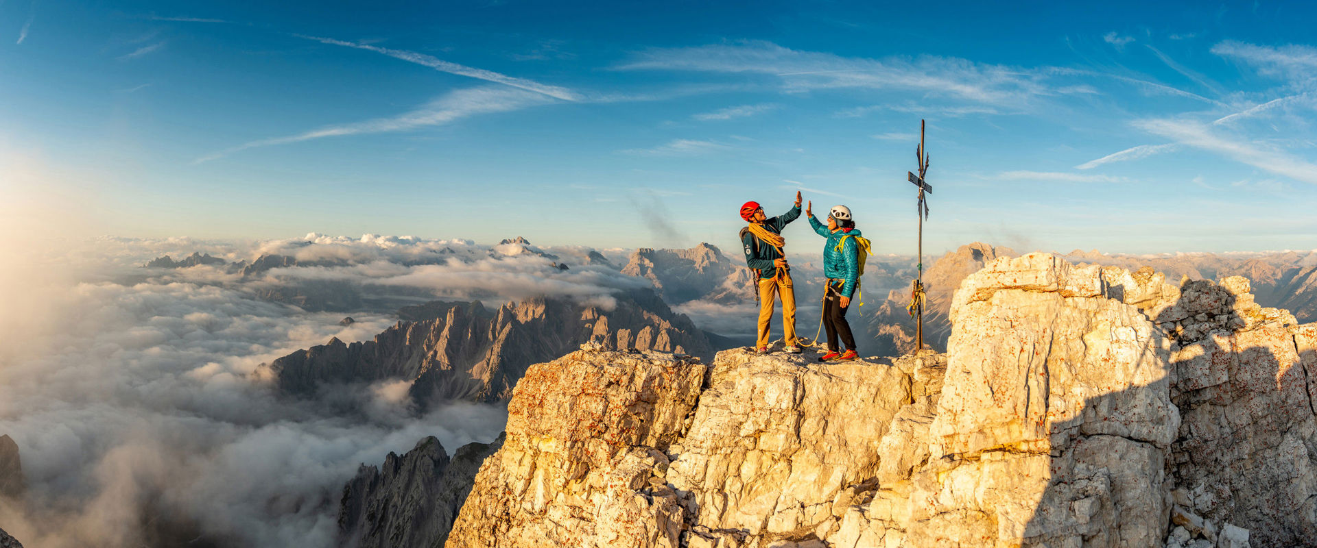Alpinschule Drei Zinnen in Sexten Zwei Kletterer feiern ihre Ankunft am Gipfelkreuz.