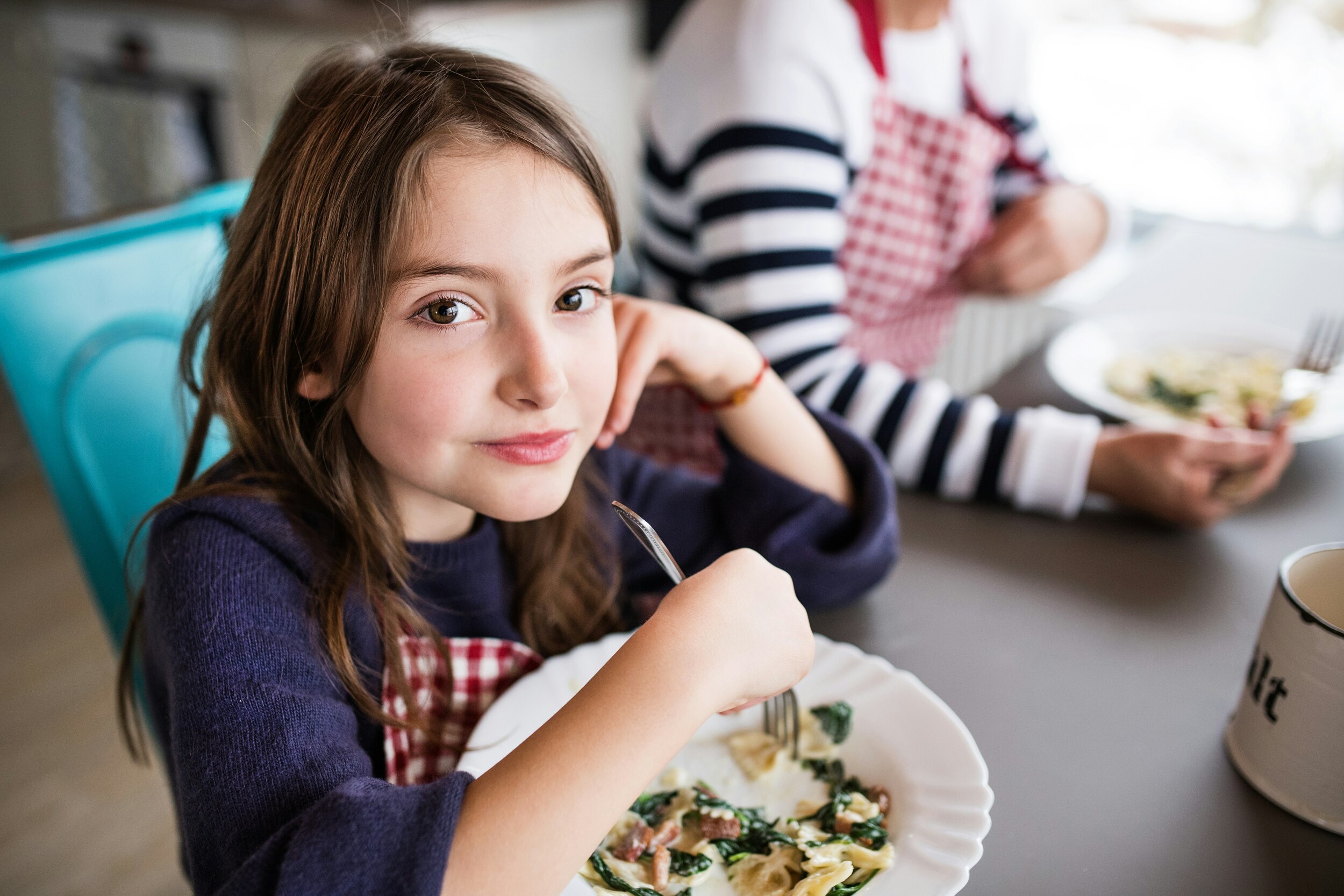 Kindern sitzen an einem Tisch um etwas zu essen.