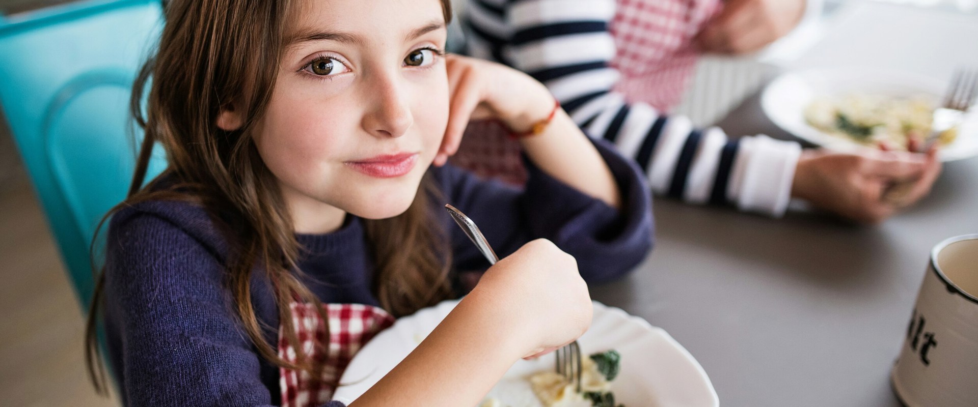 Essen auf der Skipiste Kindern sitzen an einem Tisch um etwas zu essen.