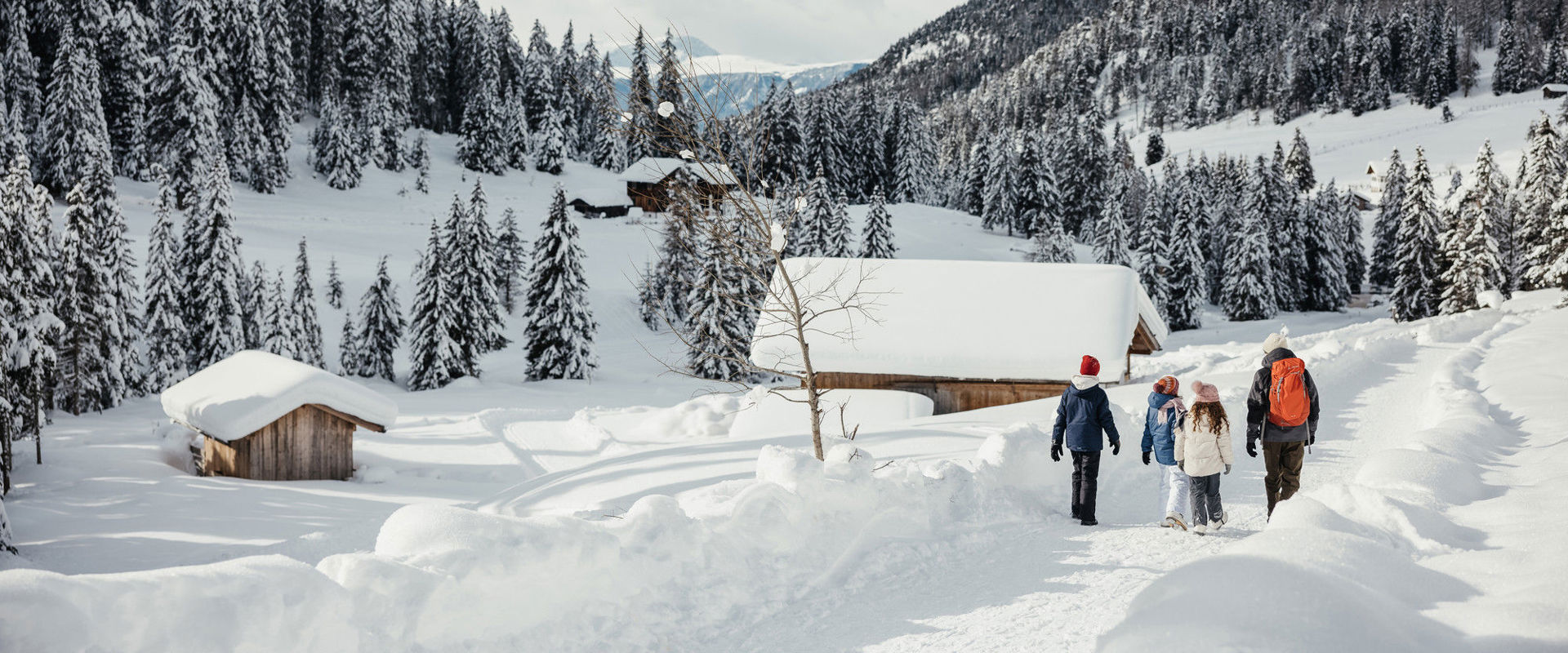 Winterlandschaft Kinder und ein Erwachsener gehen in der Schneelandschaft spazieren.
