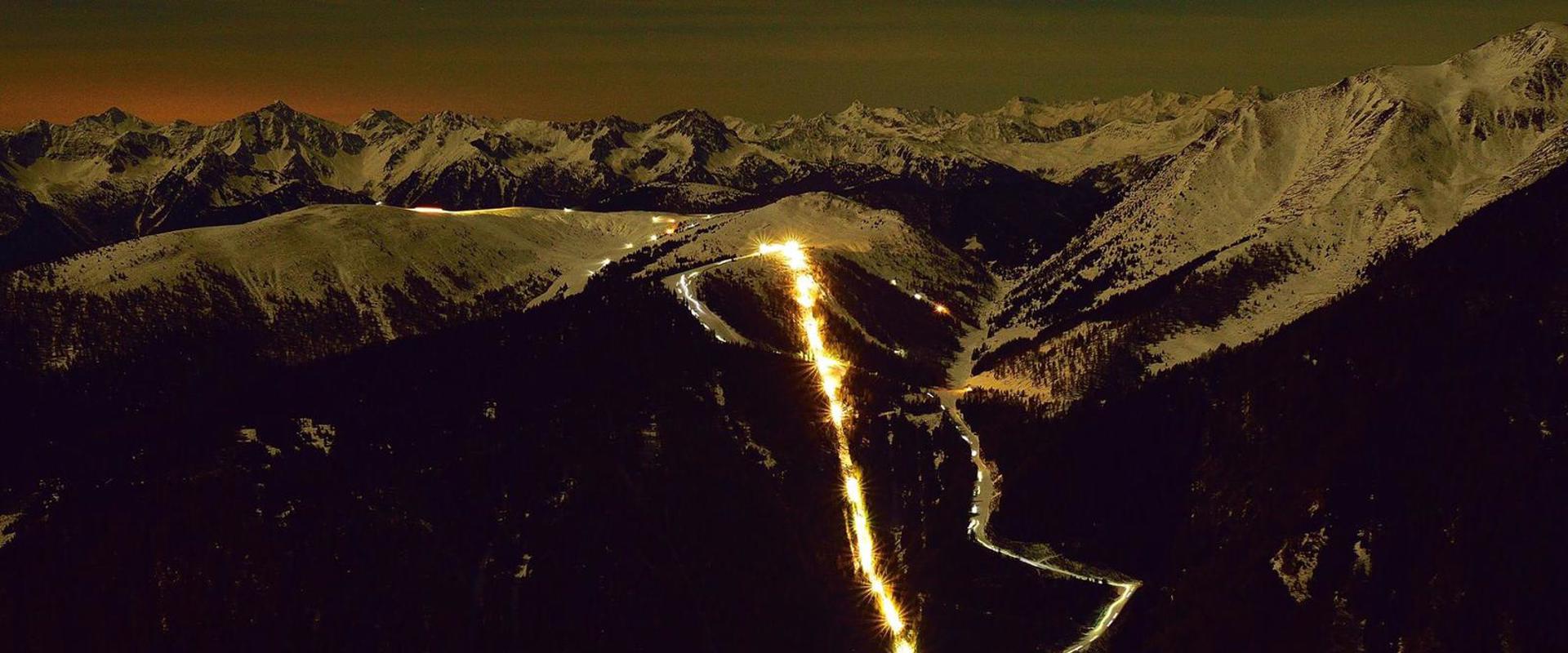 Skitourenabend Jochtal Blick auf die beleuchtete Bergbahn Jochtal und die winterliche Bergwelt beim Skitourenabend.