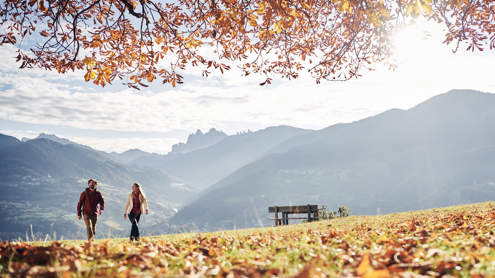 Mann und Frau gehen in der herbstlichen Landschaft spazieren.
