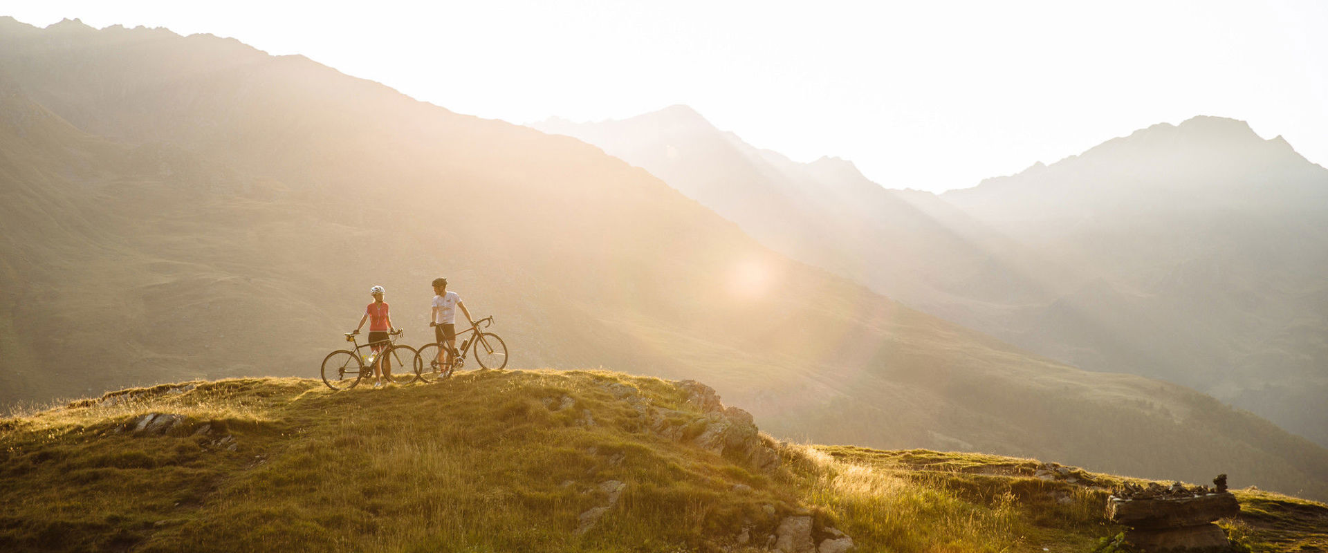 Radfahren am Berg 2 Radfahrer stehen inmitten einer atemberaubenden Berglandschaft.