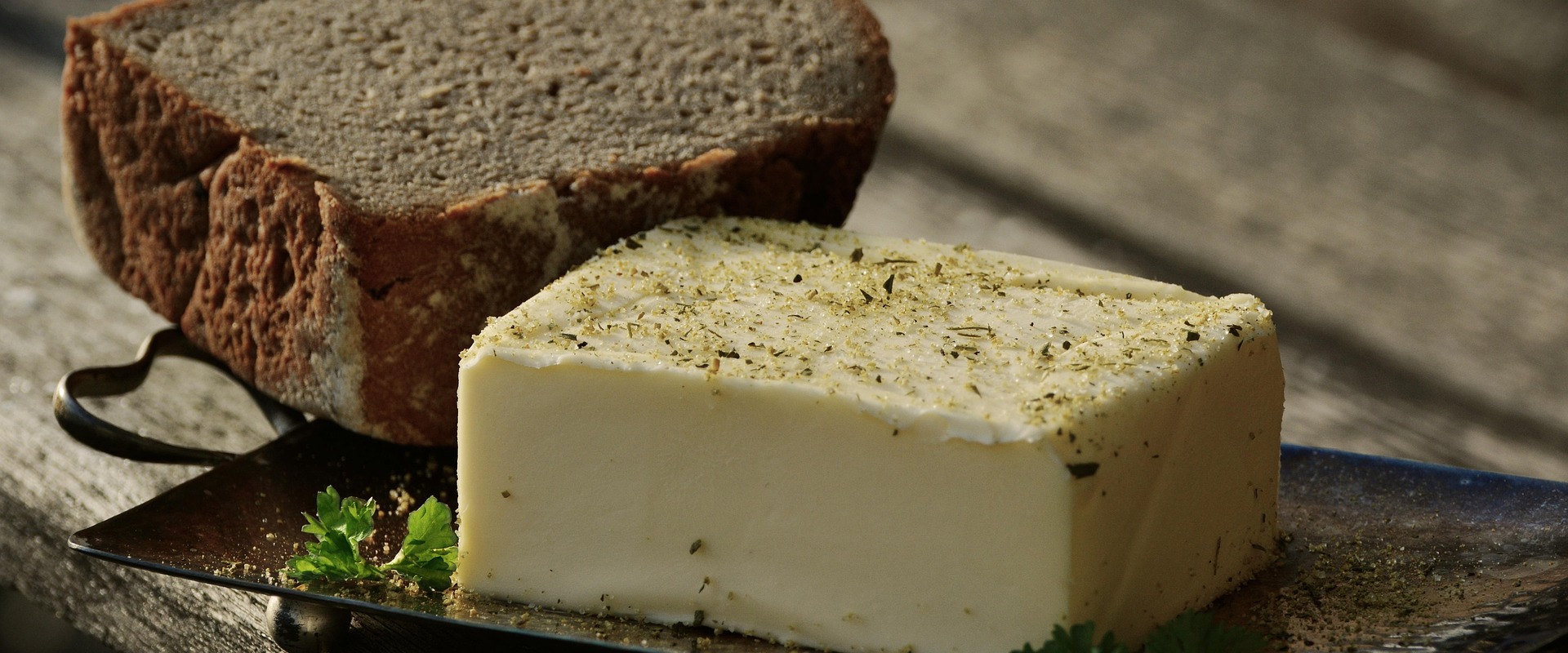 Ein Stück Butter mit Kräutersalz und Schwarzbrot