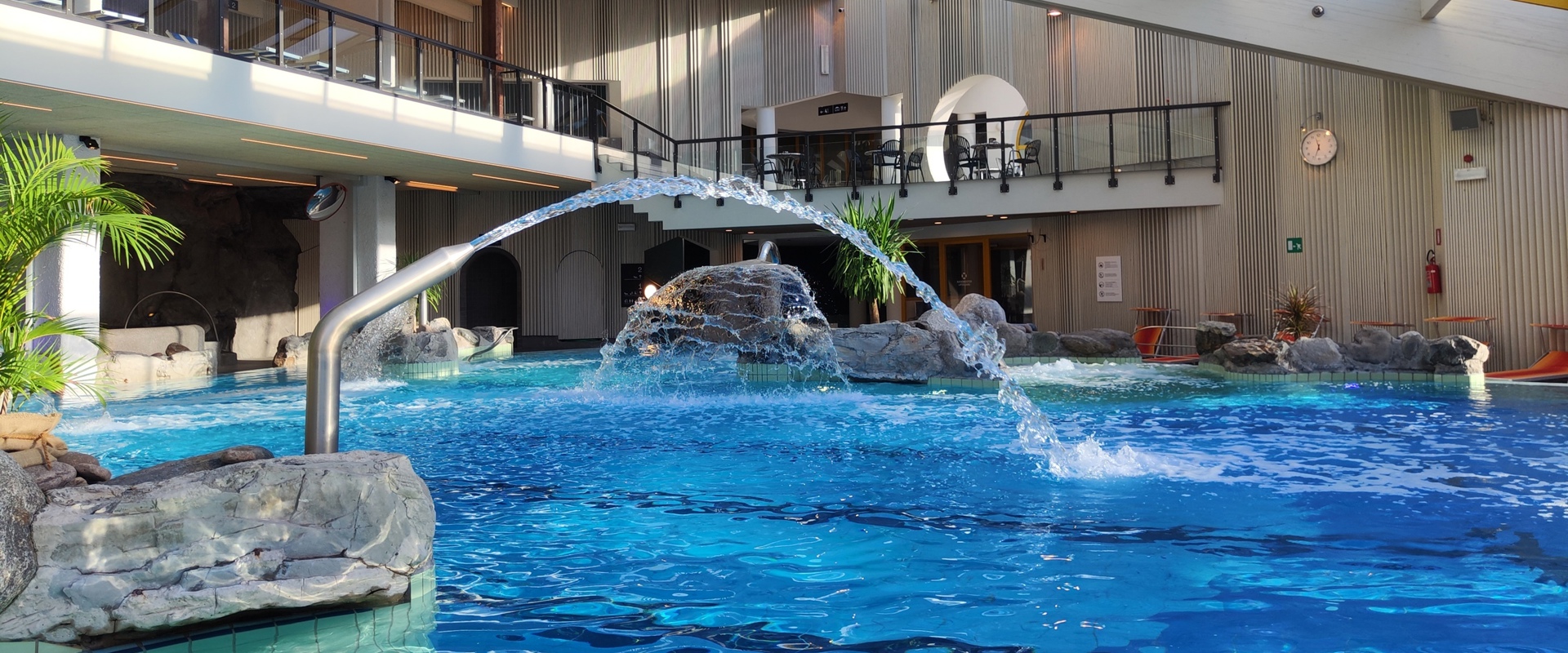 Innenbereich des Erlebnisbads Naturns Innenbereich des Schwimmbads mit Wasserrutsche, Massageliegen, Solebecken und Strömungskanal.