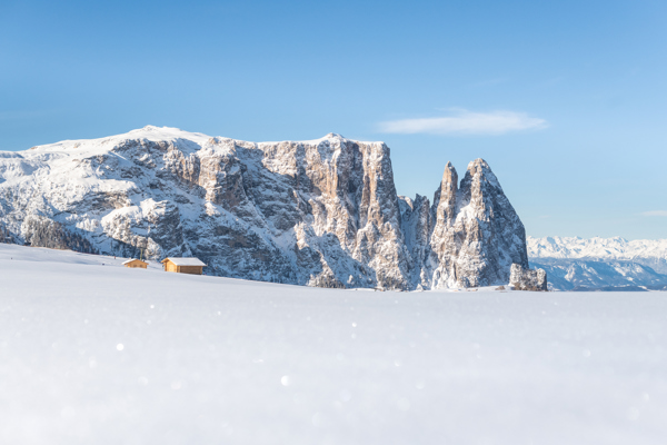 Schneebedecktes Felsprofil des Schlern hinter glitzernd weißer Schneelandschaft