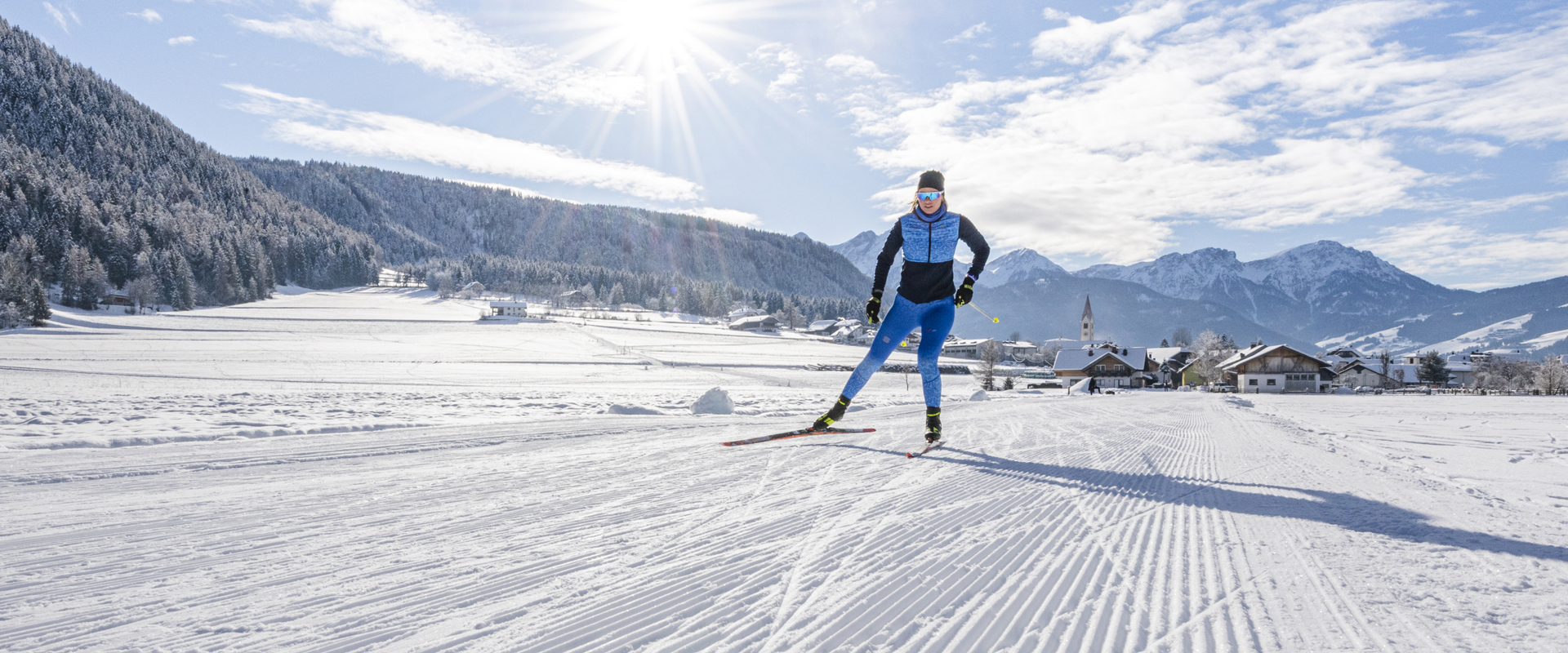 Langläuferin beim Sport auf der Loipe bei strahlendem Winterwetter