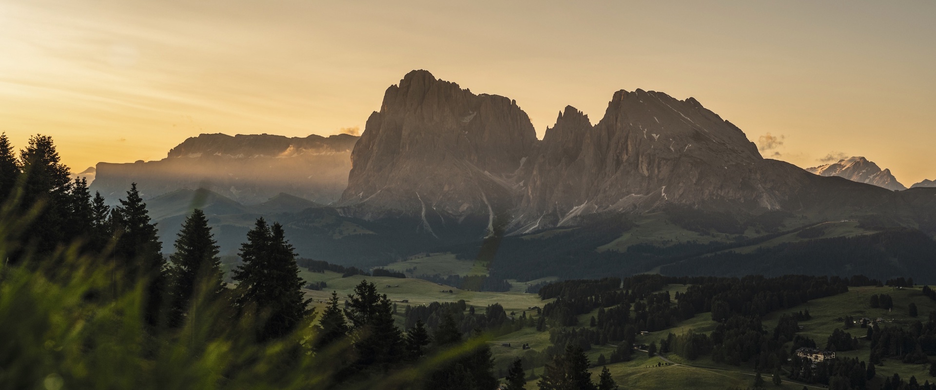 Sanft gewellte, grüne Landschaft der Seiser Alm Hochebene mit Bergmassiv im Zentrum