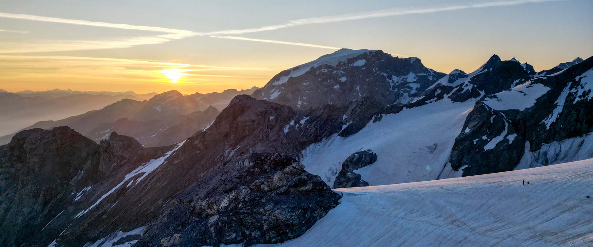 Sonnenaufgang über schneebedeckten Felsspitzen eines Gletschers