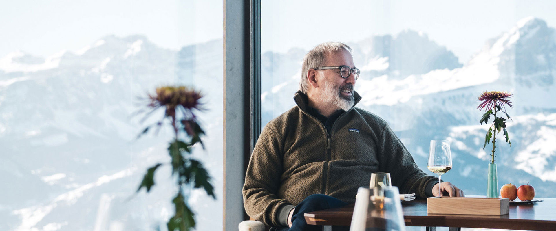 Der Starkoch Norbert Niederkofler sitzt an einem Tisch in dem Restaurant Alpinn.